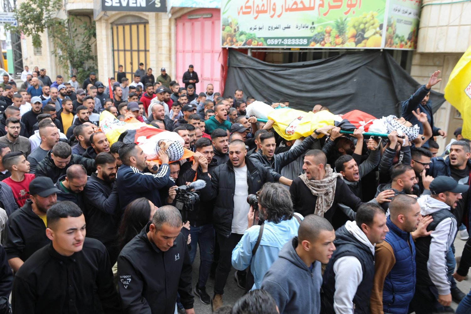 مشيعون يحملون جثتي فلسطينيين قتلا خلال اشتباكات في جنازتهما بالقرب من الخليل بالضفة الغربية (رويترز)