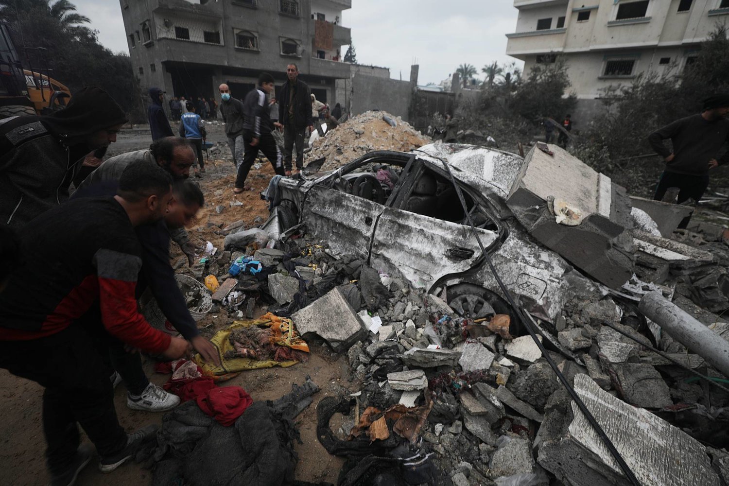 فلسطينيون يبحثون بين أنقاض منزل مدمر بعد الغارات الجوية الإسرائيلية على دير البلح جنوب قطاع غزة 5 ديسمبر 2023 (إ.ب.أ)