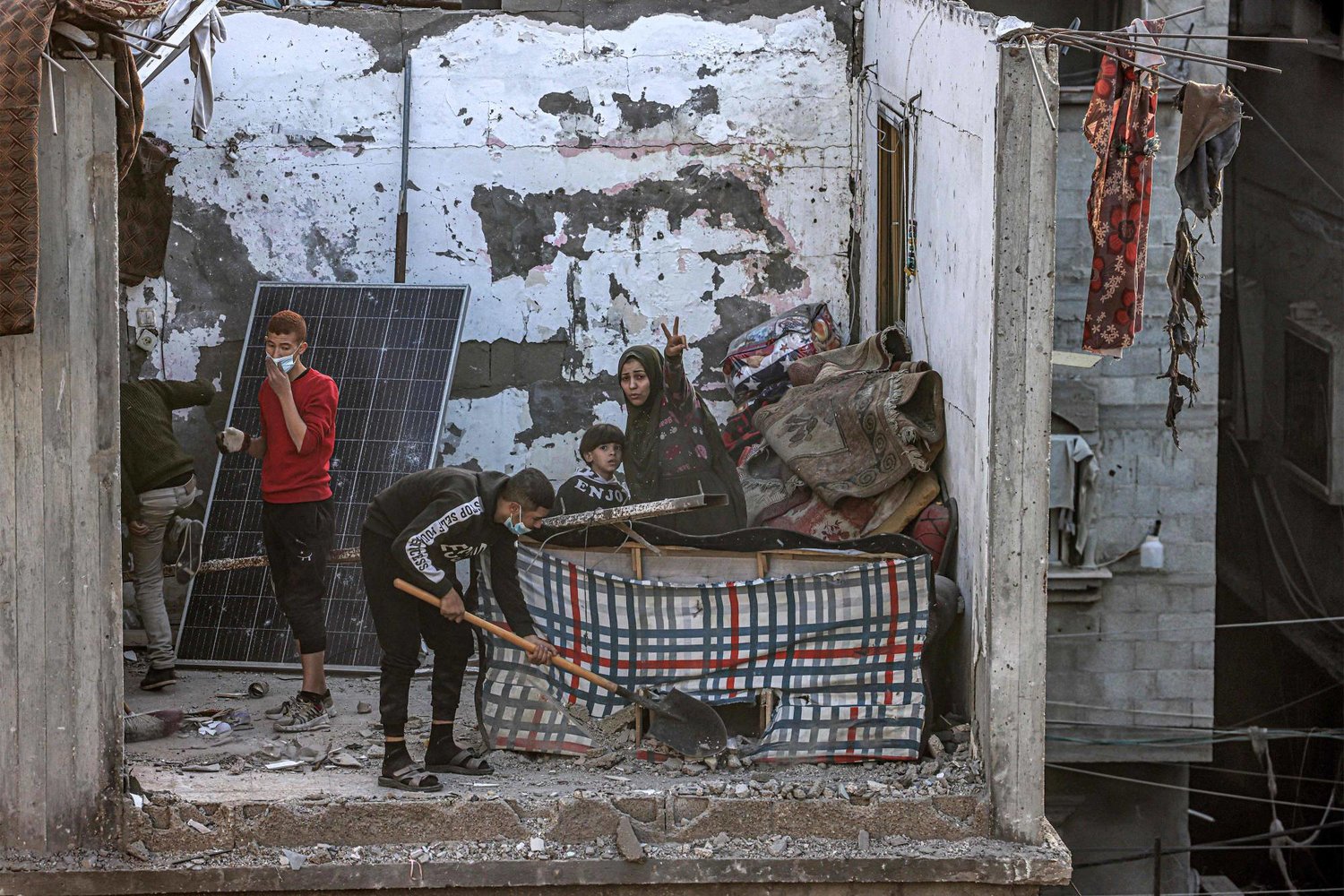فلسطيني يزيل الركام من حجرة تطل على منزل دمره القصف الإسرائيلي على رفح جنوب قطاع غزة أمس (أ.ف.ب)