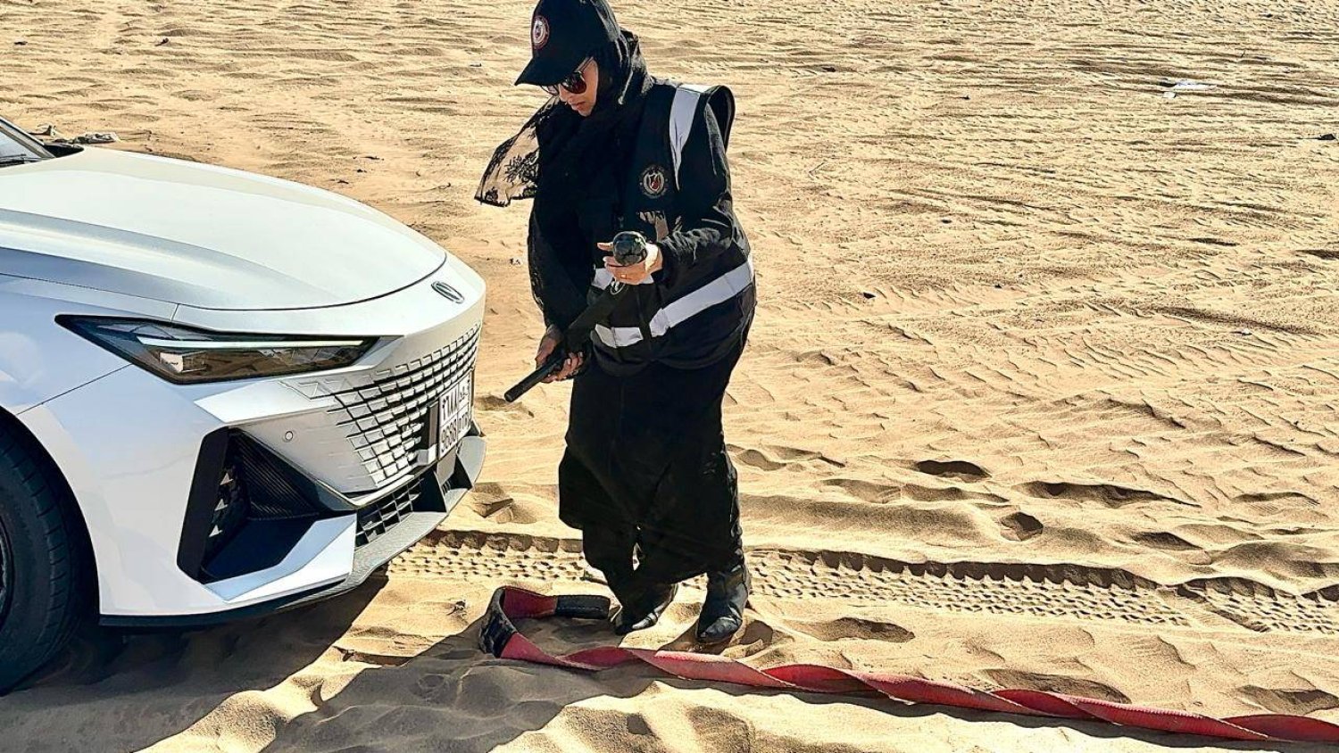 نورة الحميدي قائدة الفريق النسائي «برق للإنقاذ» أثناء سحبها إحدى السيارات العالقة في الصحراء (برق للإنقاذ)