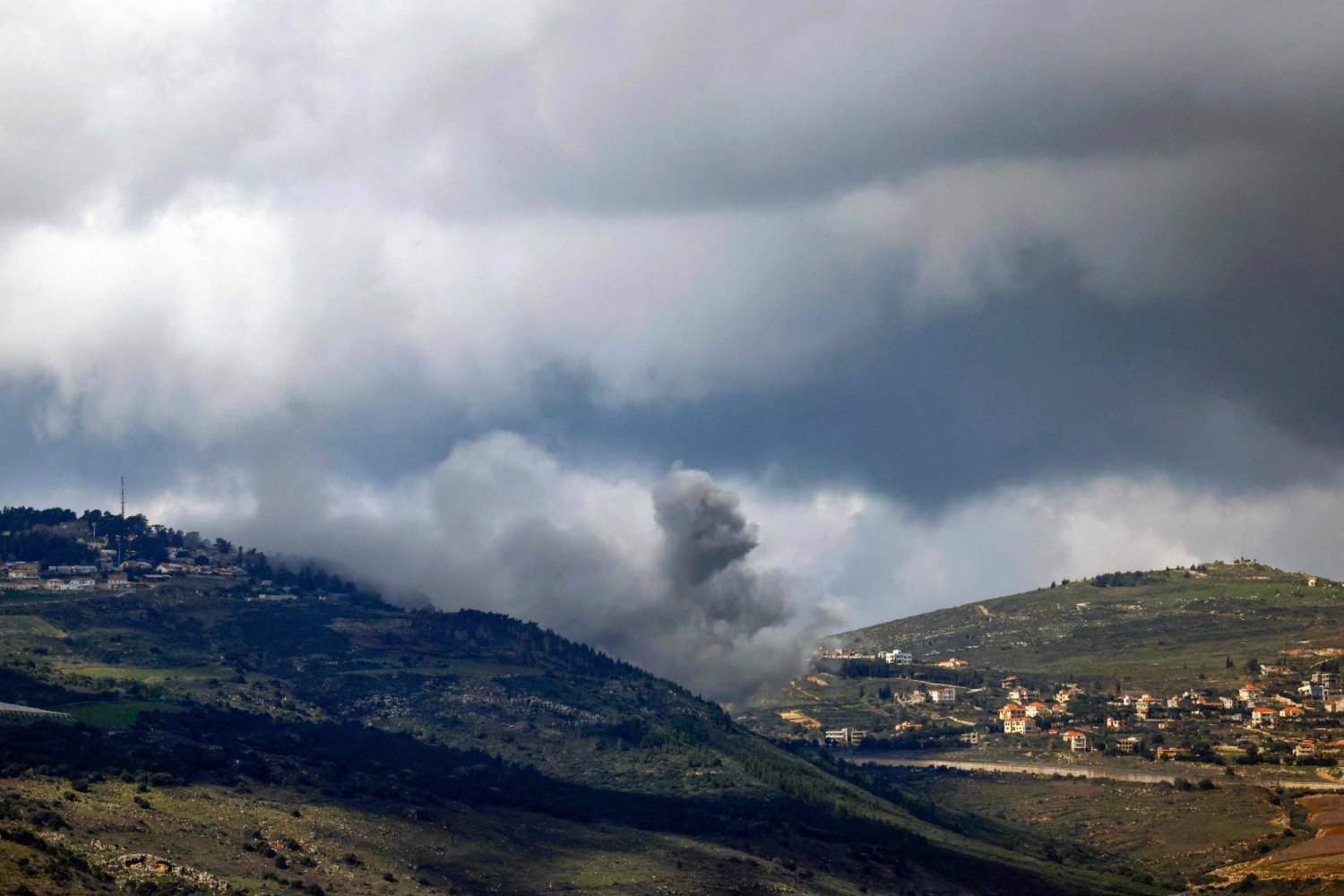 دخان يتصاعد من موقع بين قريتَي العديسة ومركبا اللبنانيتين في أثناء القصف الإسرائيلي (أ.ف.ب)