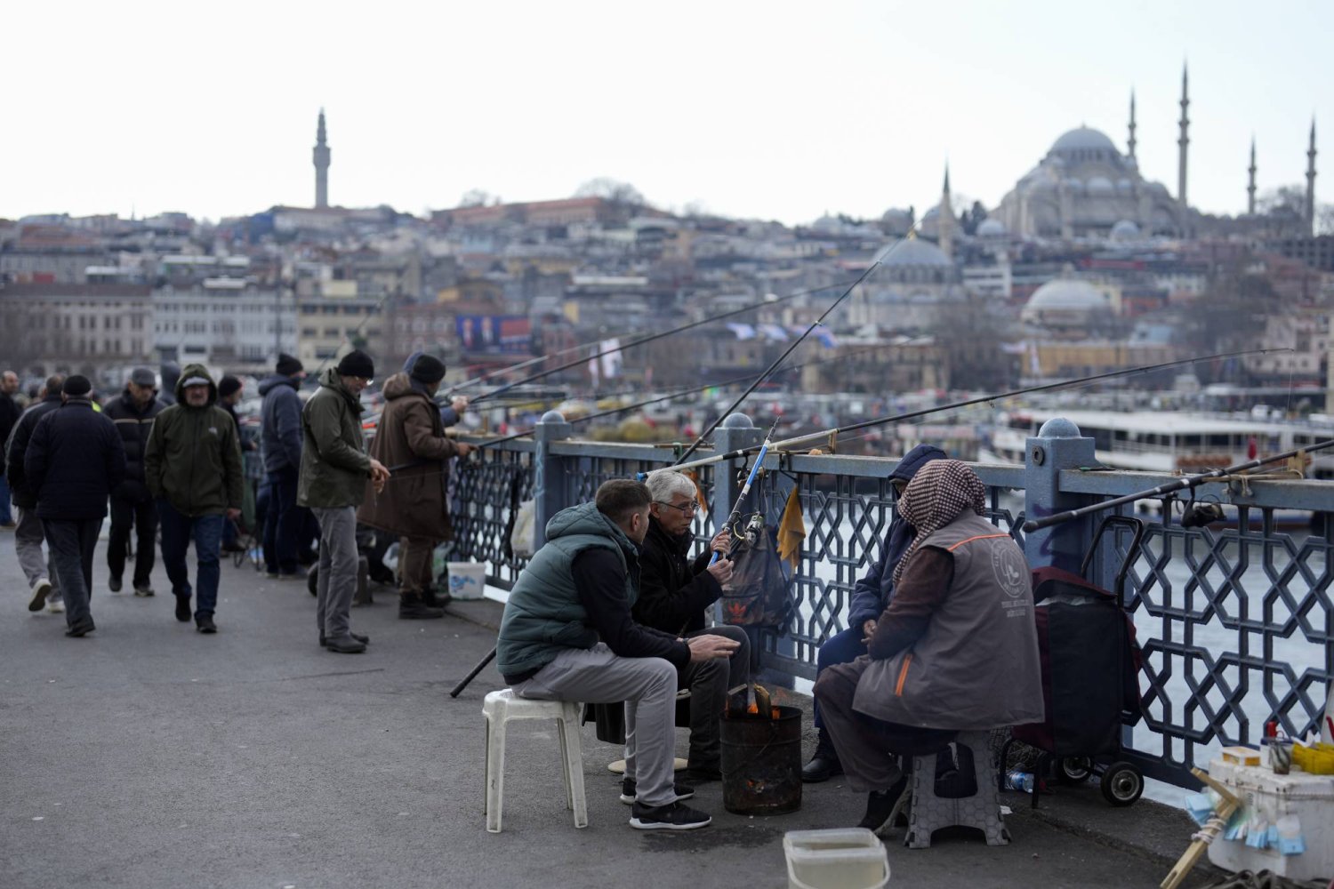 مشاة وبعض صيادي السمك على جسر «غلطة سراي» في مدينة إسطنبول التركية (أ.ب)