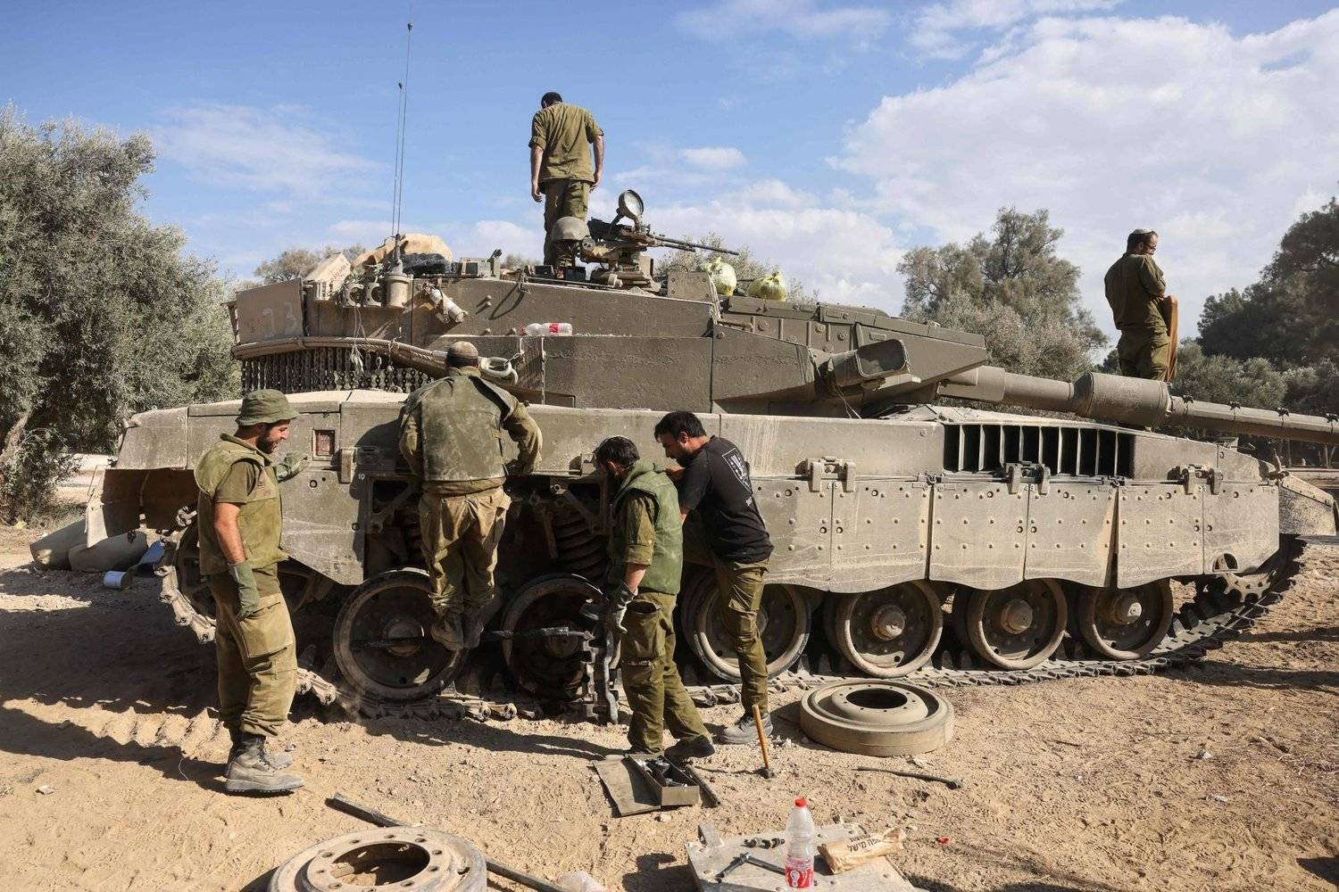جنود إسرائيليون يُجرون صيانة لدبابة (أ.ف.ب)