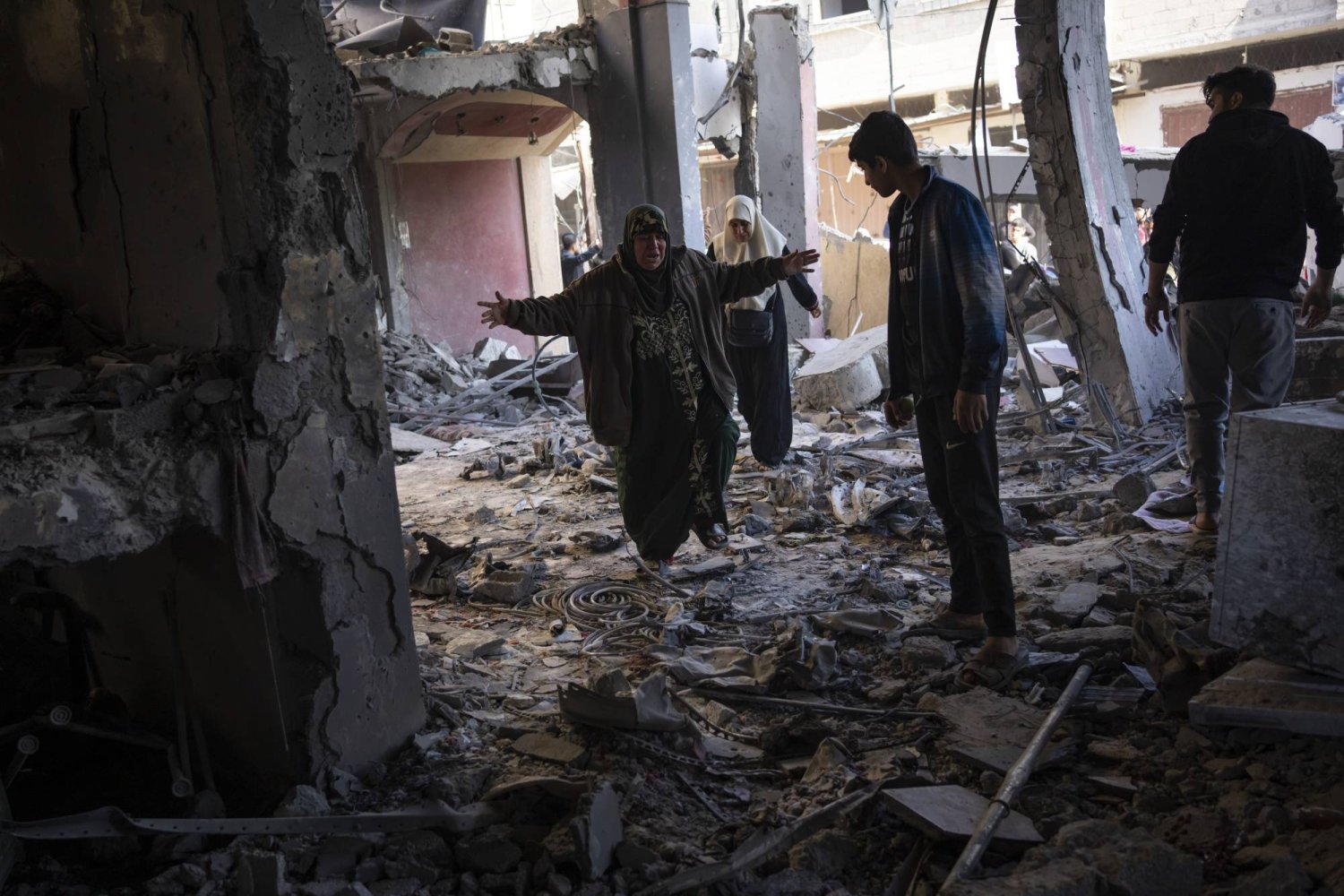 فلسطينيون داخل منزل تعرض لأضرار كبيرة نتيجة الغارات الإسرائيلية على رفح (أ.ب)