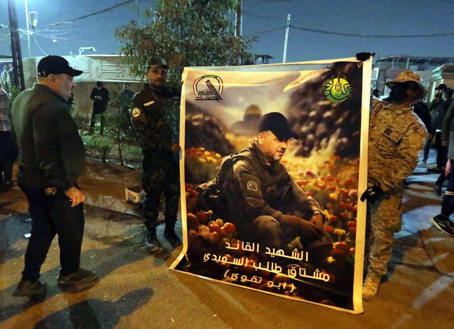 مقاتلون من فصائل «الحشد الشعبي» يحملون صورة القيادي «أبو تقوى» الذي قُتل بضربة أميركية على بغداد (إ.ب.أ)