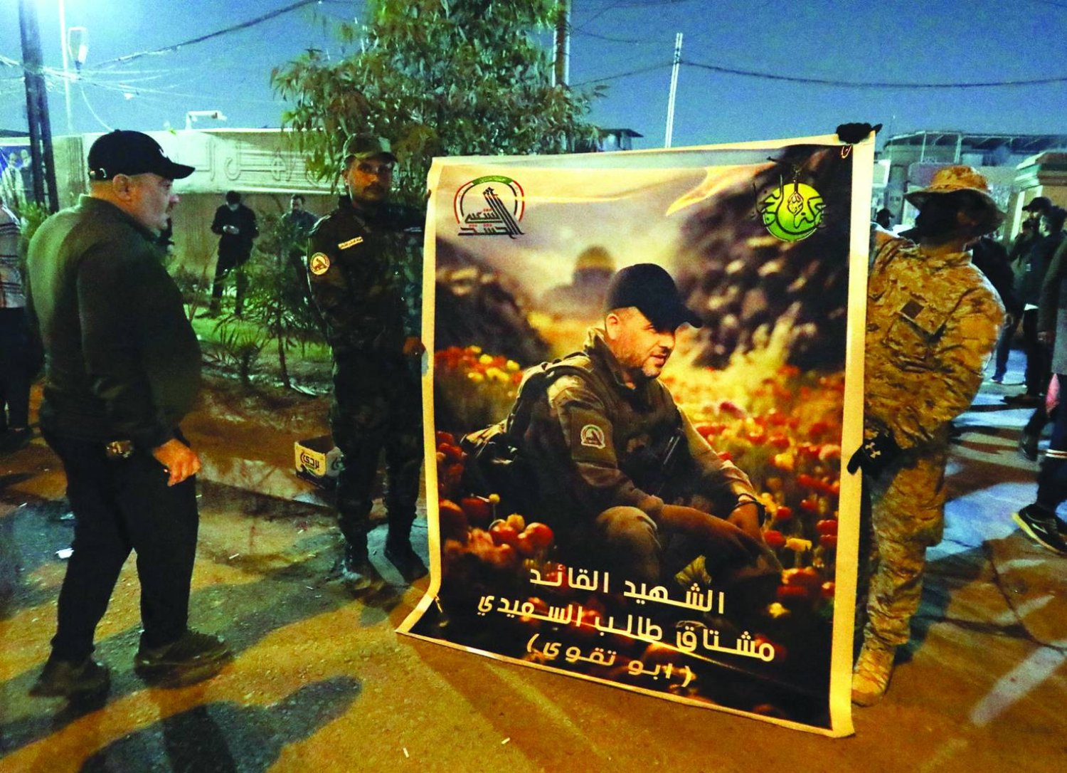
مقاتلون من فصائل «الحشد الشعبي» يحملون صورة القيادي «أبو تقوى» الذي قُتل بضربة أميركية على بغداد يناير الماضي (إ.ب.أ)