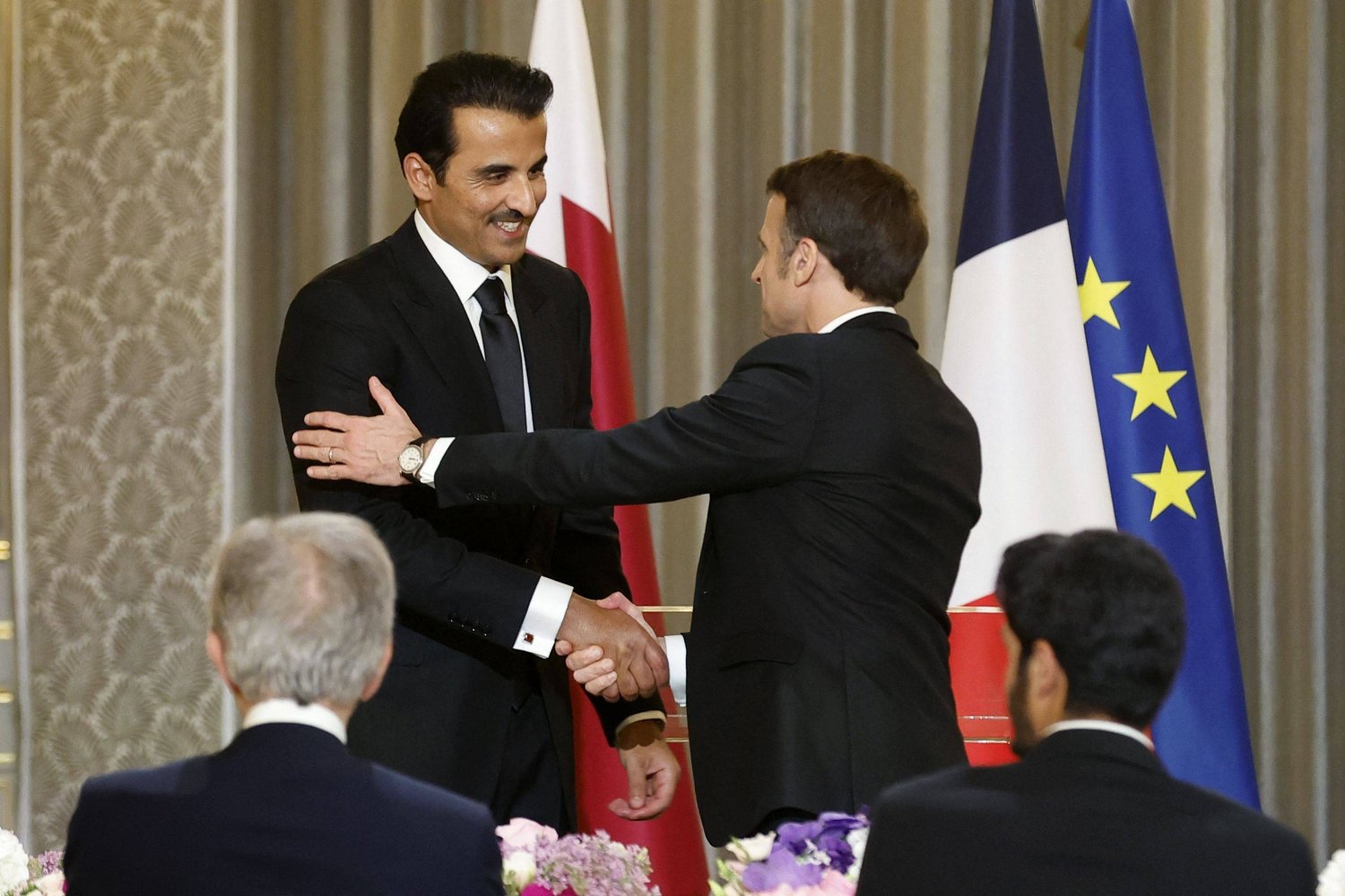 الرئيس الفرنسي إيمانويل ماكرون مرحباً بأمير قطر الشيخ تميم بن حمد آل ثاني (ا.ف.ب)