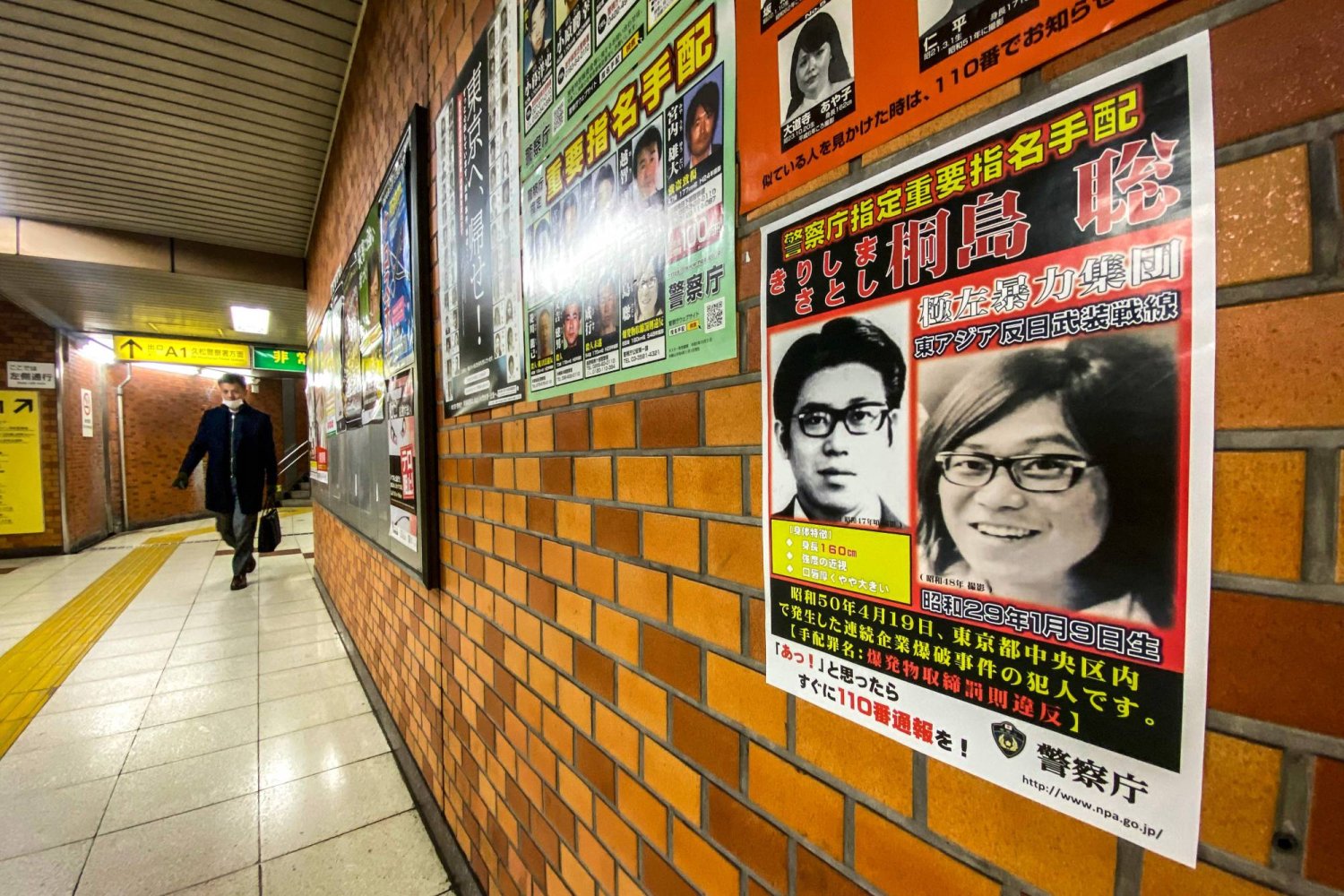 ملصق يُظهر صورة ساتوشي كيريشيما الذي كان عضواً في منظمة متطرفة مسؤولة عن هجمات في العاصمة اليابانية بالسبعينات (أ.ف.ب)