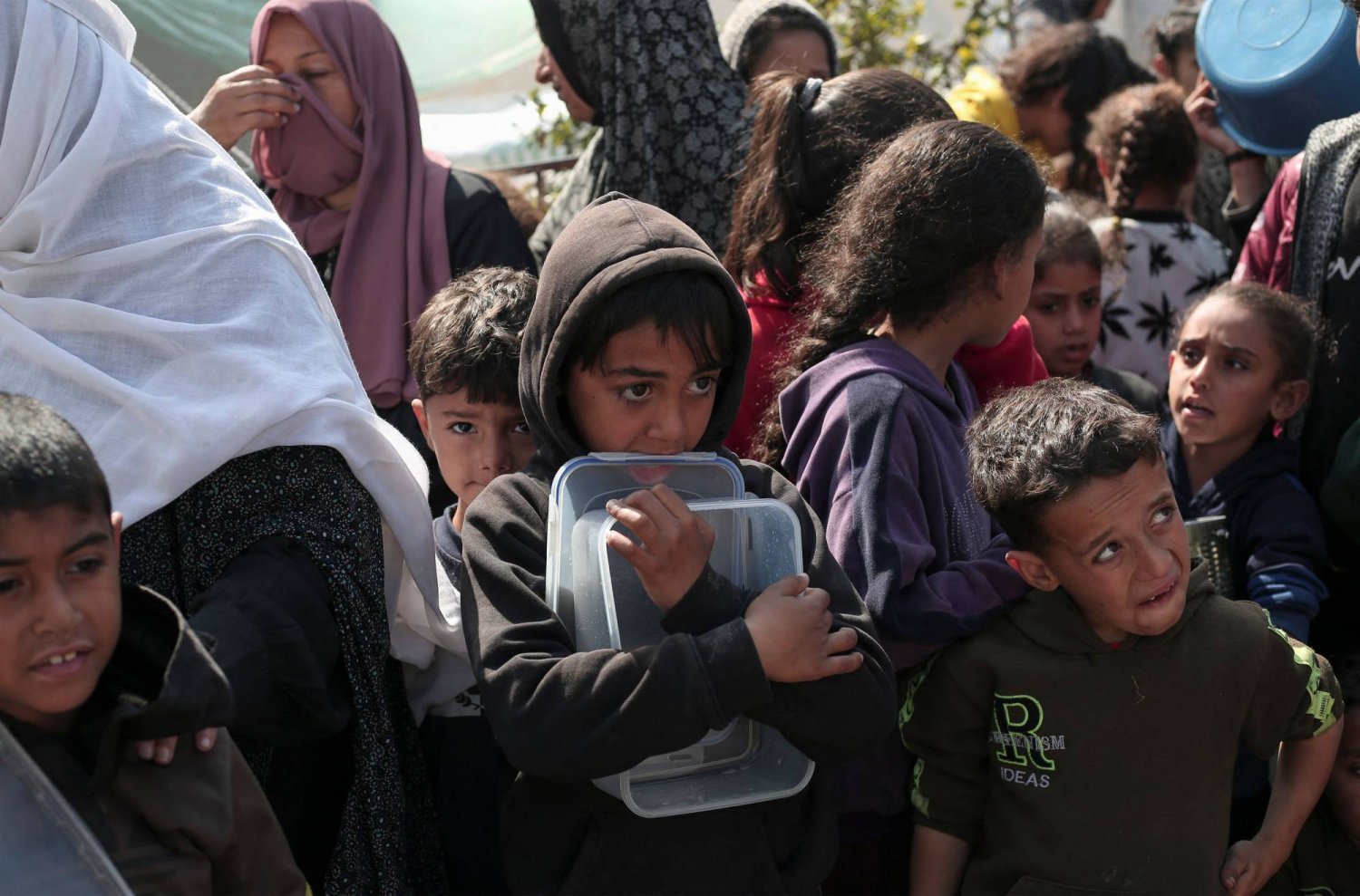 أطفال فلسطينيون يتجمعون للحصول على الطعام في رفح جنوب قطاع غزة (أ.ف.ب)