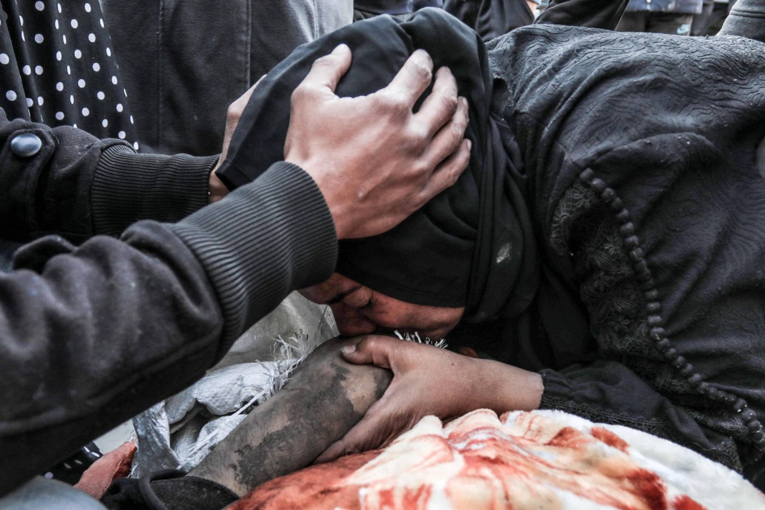 امرأة تبكي فوق جثة أحد أفراد أسرتها الذي قُتل أثناء القصف الإسرائيلي ليلاً في مستشفى «الأقصى» في دير البلح بوسط غزة (أ.ف.ب)
