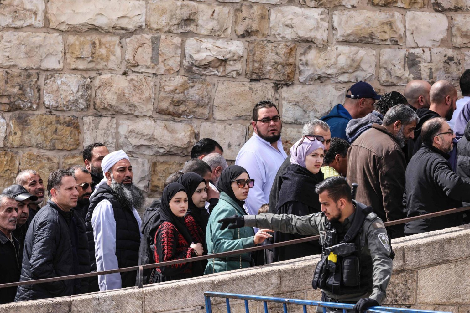 أحد أفراد قوات الأمن الإسرائيلية يقف حراسة أثناء مرور المصلين المسلمين عبر نقطة تفتيش بالقرب من باب الأسباط في القدس لدخول مجمع المسجد الأقصى لأداء صلاة الجمعة