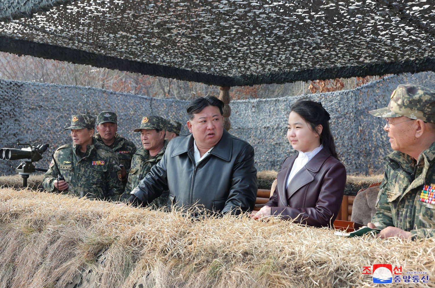 جو آي إلى جانب والدها كيم جونغ أون خلال مشاهدتهما تدريبات المظليين (أ.ف.ب)