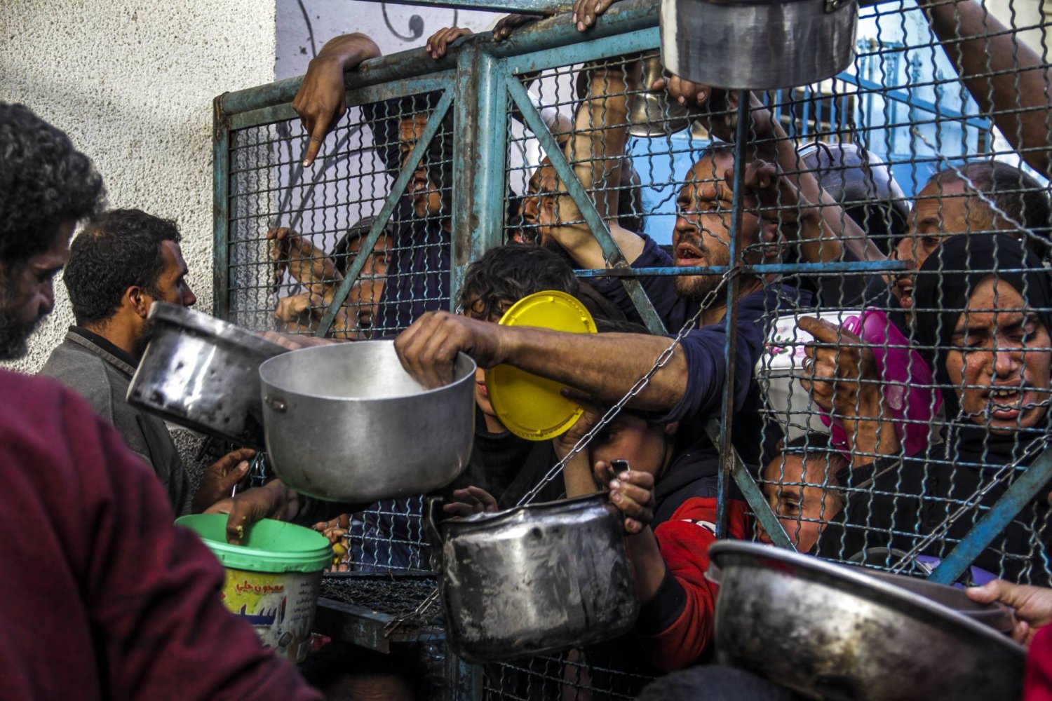 ينتظر الفلسطينيون ومن بينهم الأطفال الحصول على وجبات مجانية خلال شهر رمضان في مخيم جباليا للاجئين في قطاع غزة وسط أزمة غذاء حادة وتحذيرات من مجاعة (د.ب.أ)