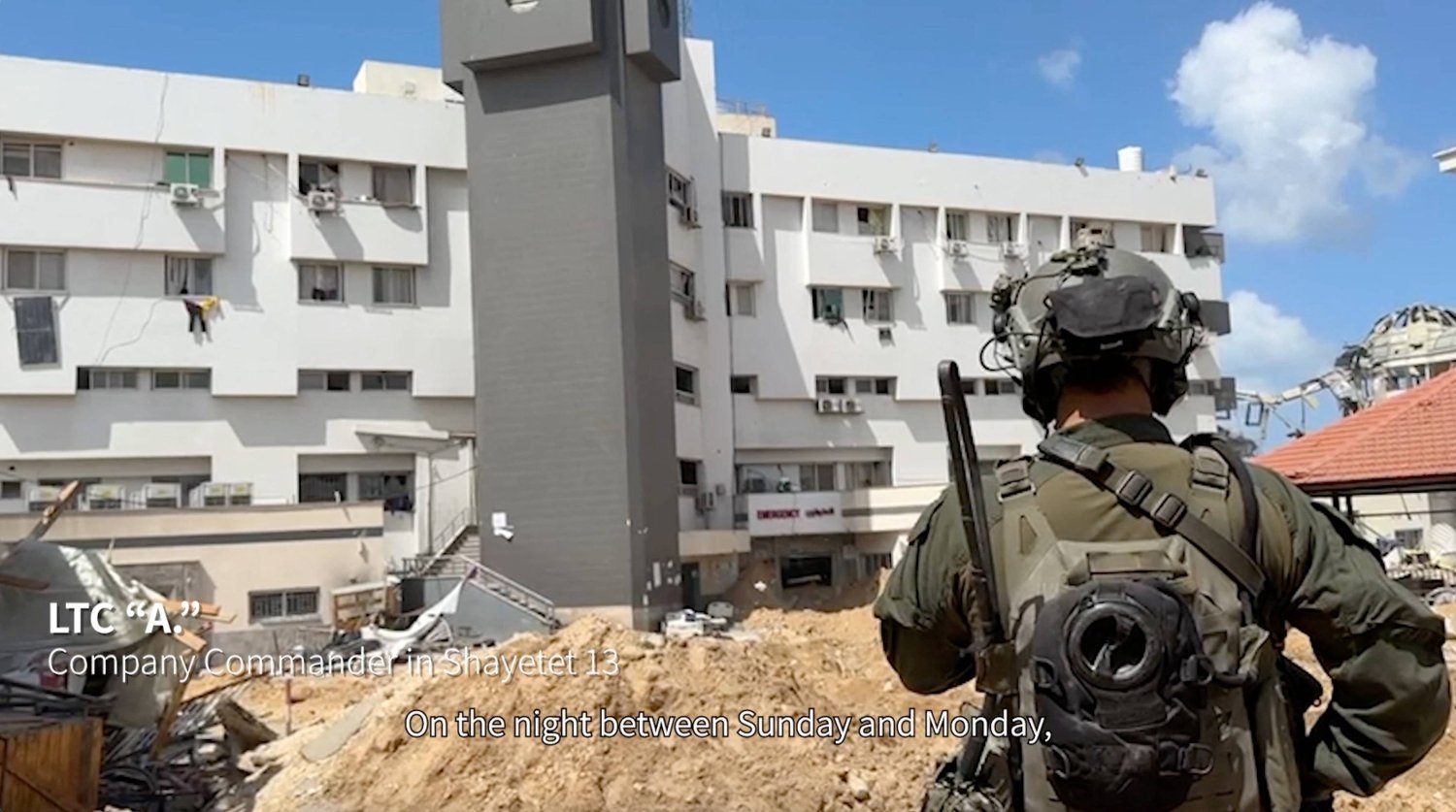 جندي إسرائيلي يقف بالقرب من مستشفى الشفاء في مدينة غزة (رويترز)