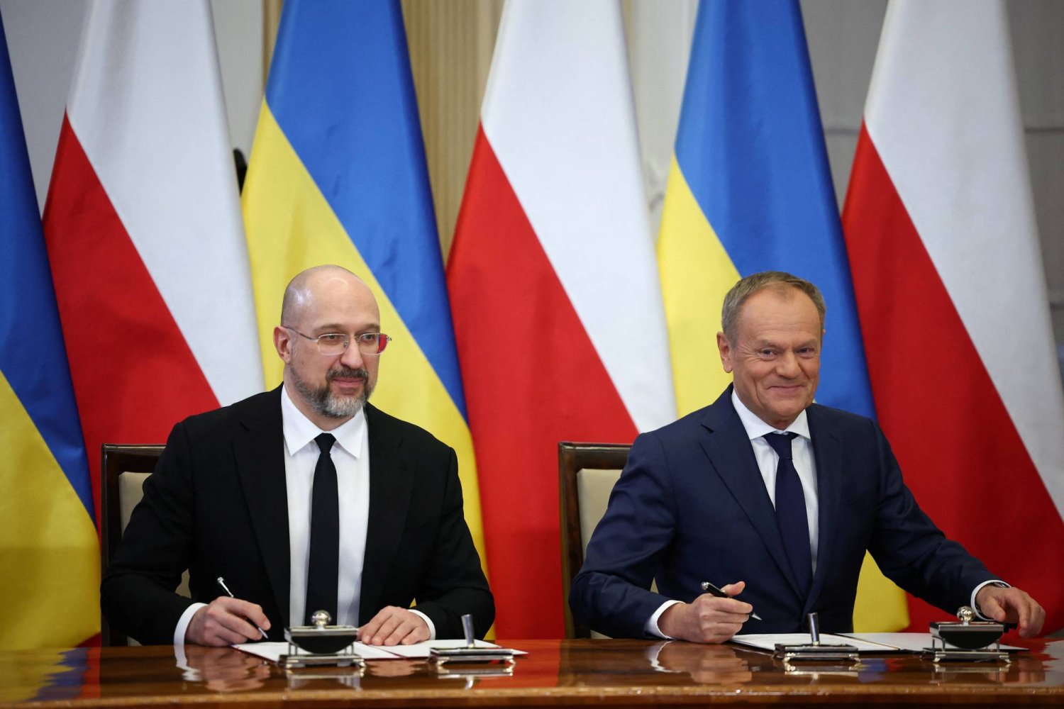 رئيس الوزراء البولندي توسك ونظيره الأوكراني شميهال خلال محادثات ثنائية في وارسو (رويترز)