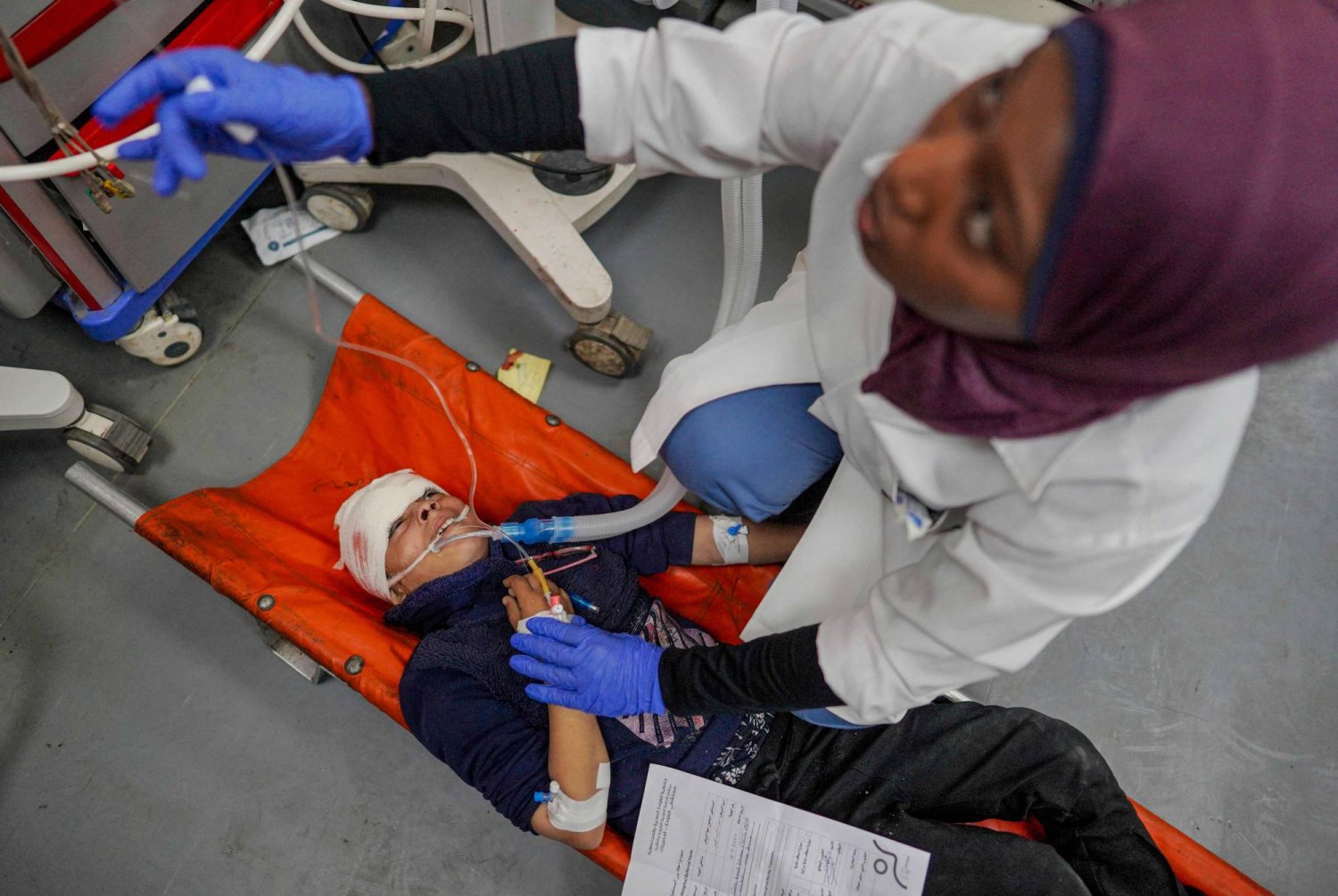 ممرضة تحاول إسعاف طفل في مستشفى «شهداء الأقصى» في غزة (أ.ف.ب)