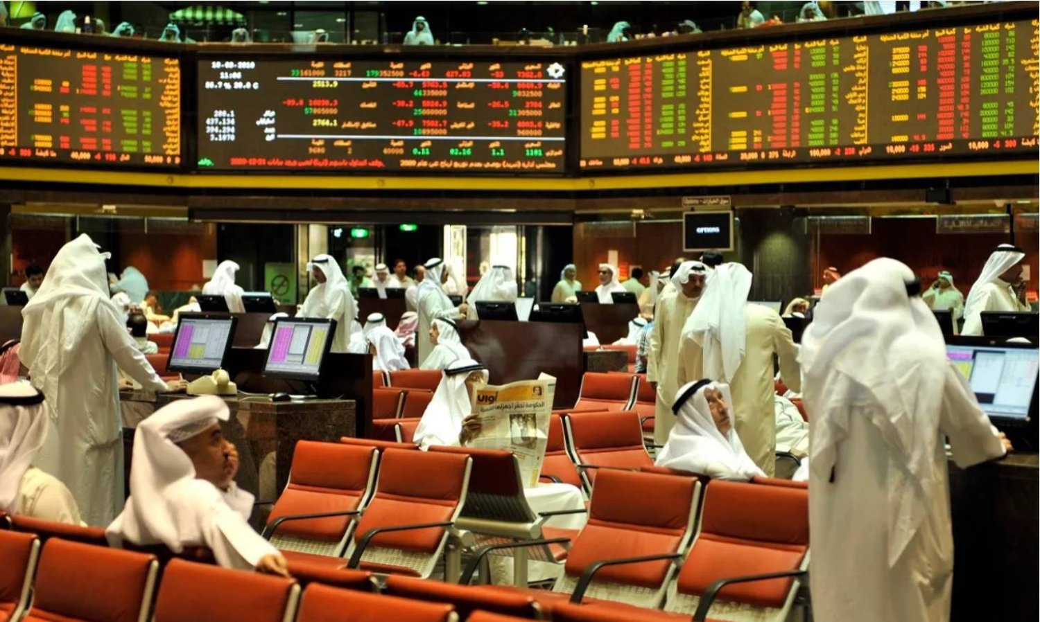 مستثمرون يتابعون تحركات الأسهم والسندات في صالة تداول ببورصة الكويت (رويترز)