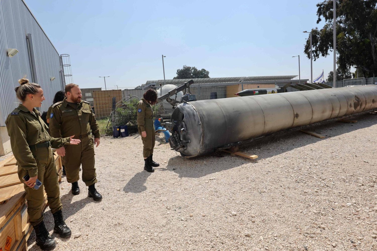 أفراد من الجيش الإسرائيلي يقفون بجانب صاروخ باليستي إيراني سقط في إسرائيل في نهاية الأسبوع (أ.ف.ب)