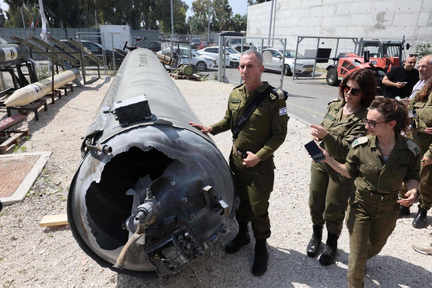 أفراد من الجيش الإسرائيلي  يعرضون بقايا صاروخ باليستي إيراني (ا.ف.ب)