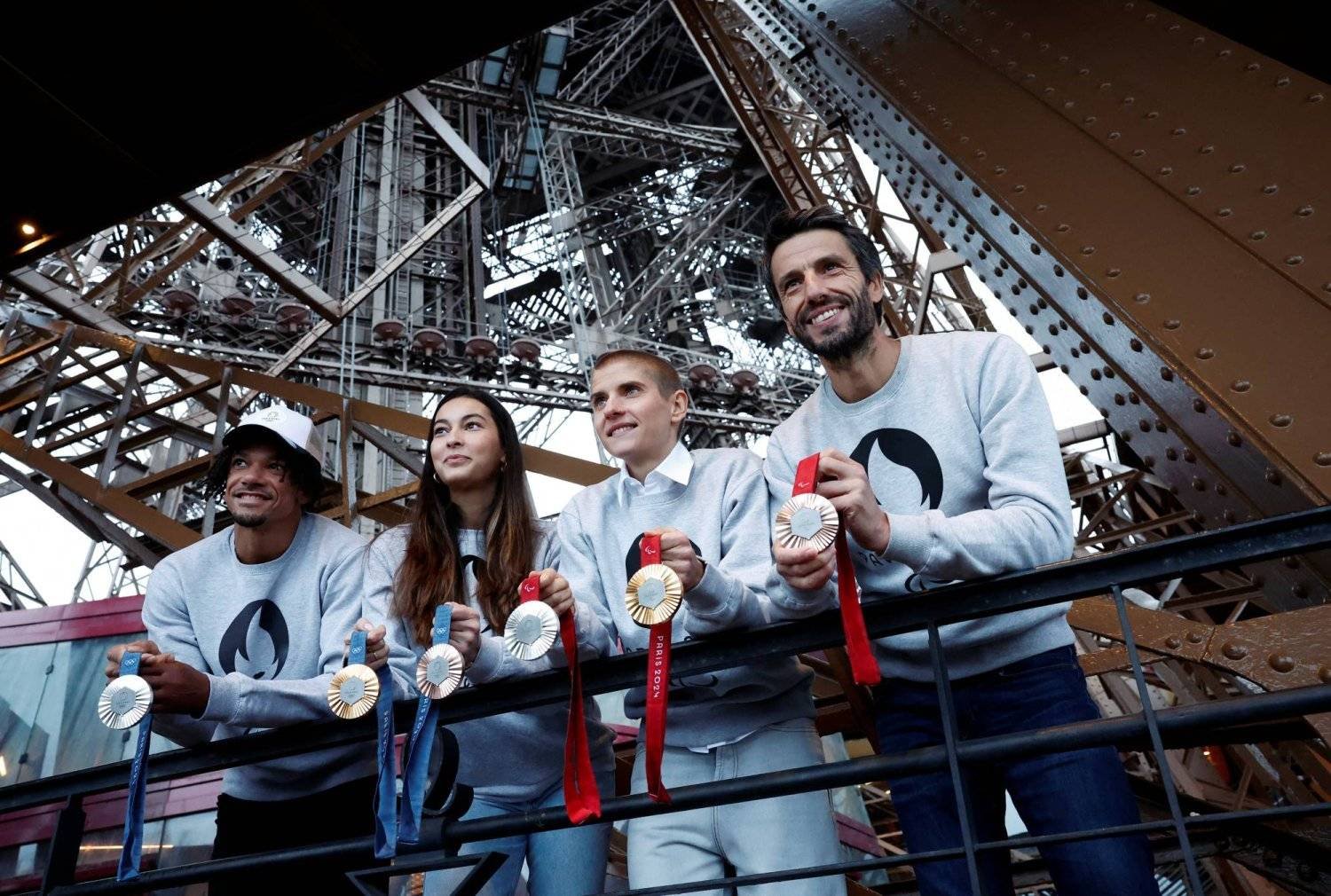 رئيس اللجنة المنظمة لـ«أولمبياد باريس» يستعرض الميداليات تحت برج إيفل (رويترز)