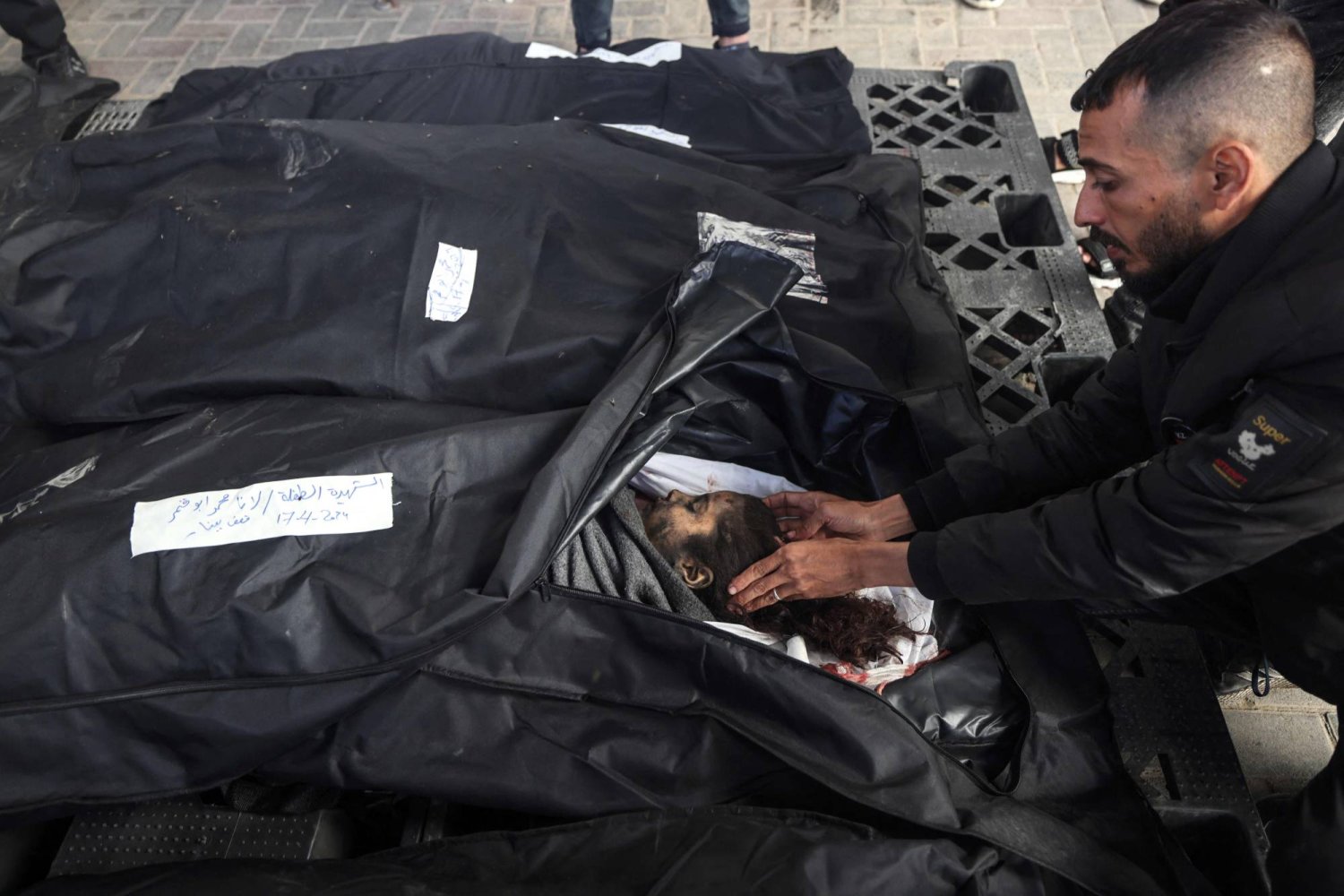 رجل يقف أمام رأس طفلة قُتلت في القصف الإسرائيلي أمس في رفح بجنوب قطاع غزة (أ.ف.ب)