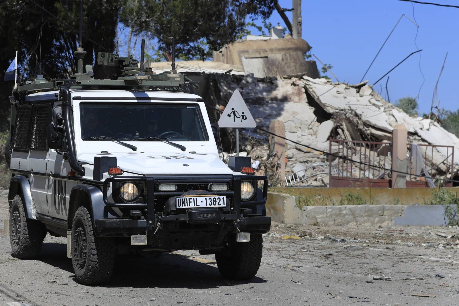 سيارة لـ«يونيفيل» في بلدة علما الشعب بجنوب لبنان إلى جانب منزل دمرته غارة إسرائيلية (أ.ب)