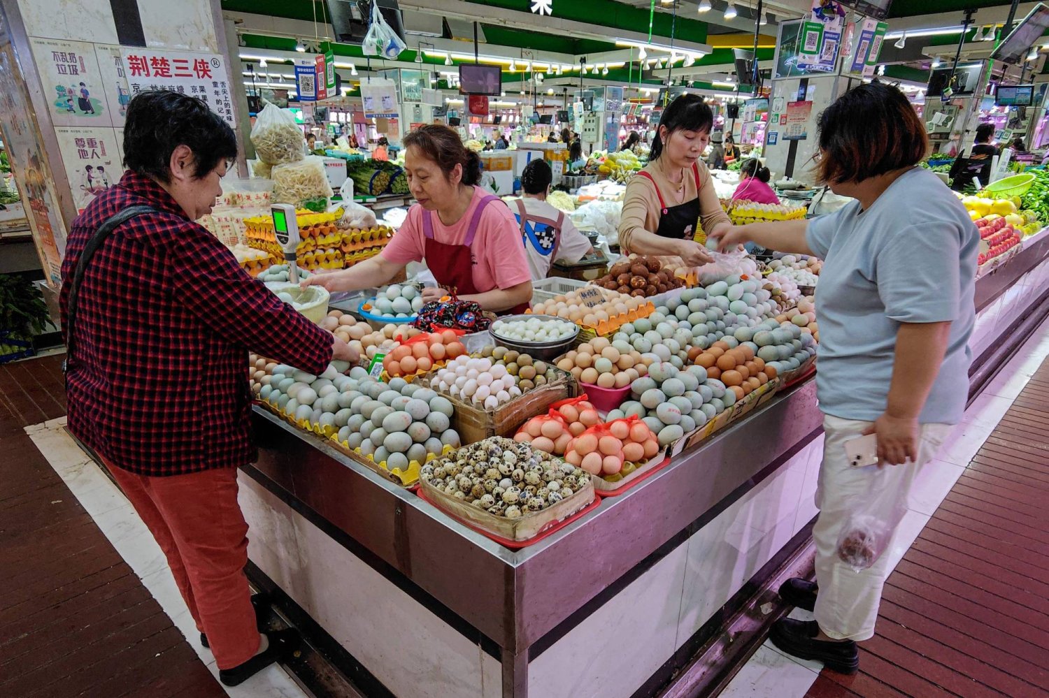 صينيون يتبضعون في إحدى الأسواق الشعبية بمدينة ووهان الصينية (أ.ف.ب)