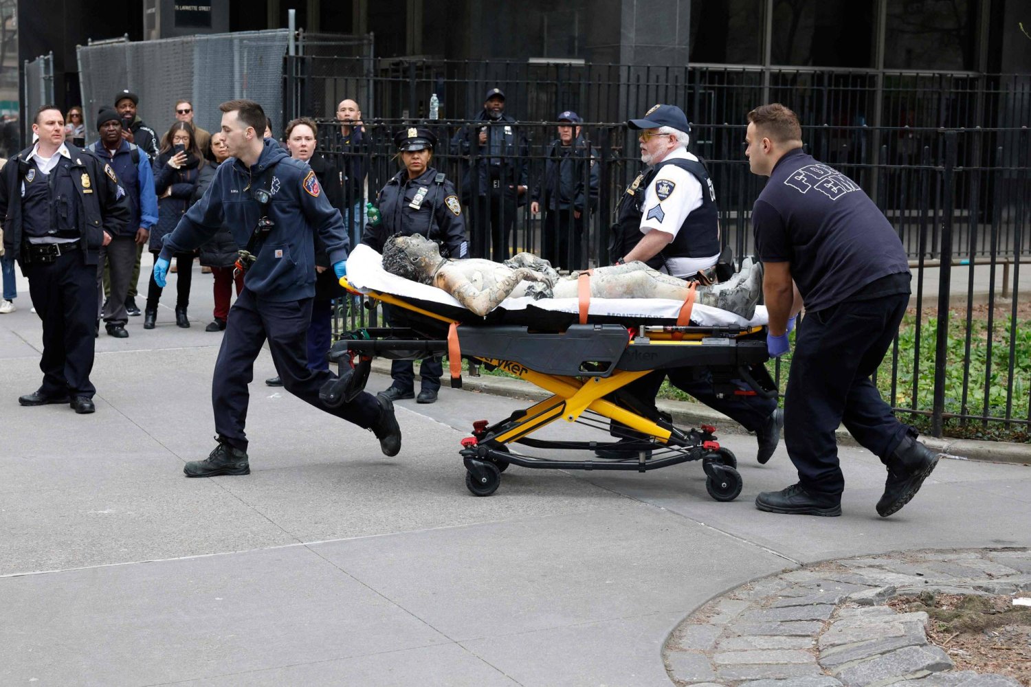 المسعفون ينقلون رجلا أشعل النار في نفسه بالقرب من محكمة مانهاتن اليوم (أ.ف.ب)
