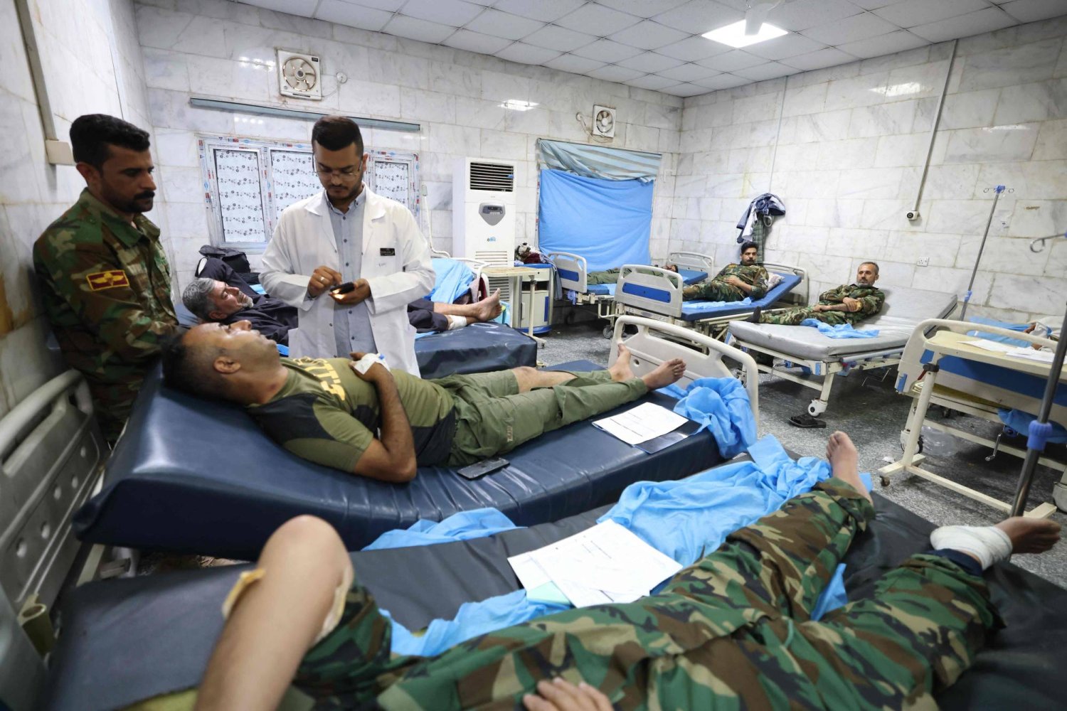 عسكريون عراقيون يتلقون العلاج في مستشفى في الحلة بمحافظة بابل بعد إصابتهم في قصف خلال الليل على قاعدة عسكرية (أ.ف.ب)