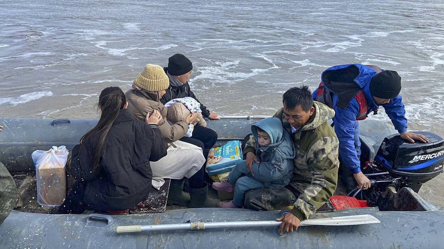 رجال إنقاذ تابعون لوزارة الطوارئ الكازاخستانية يقومون بإجلاء السكان من منطقة الفيضانات في كاراتشاجاناك في غرب دولة كازاخستان  (إ.ب.أ)