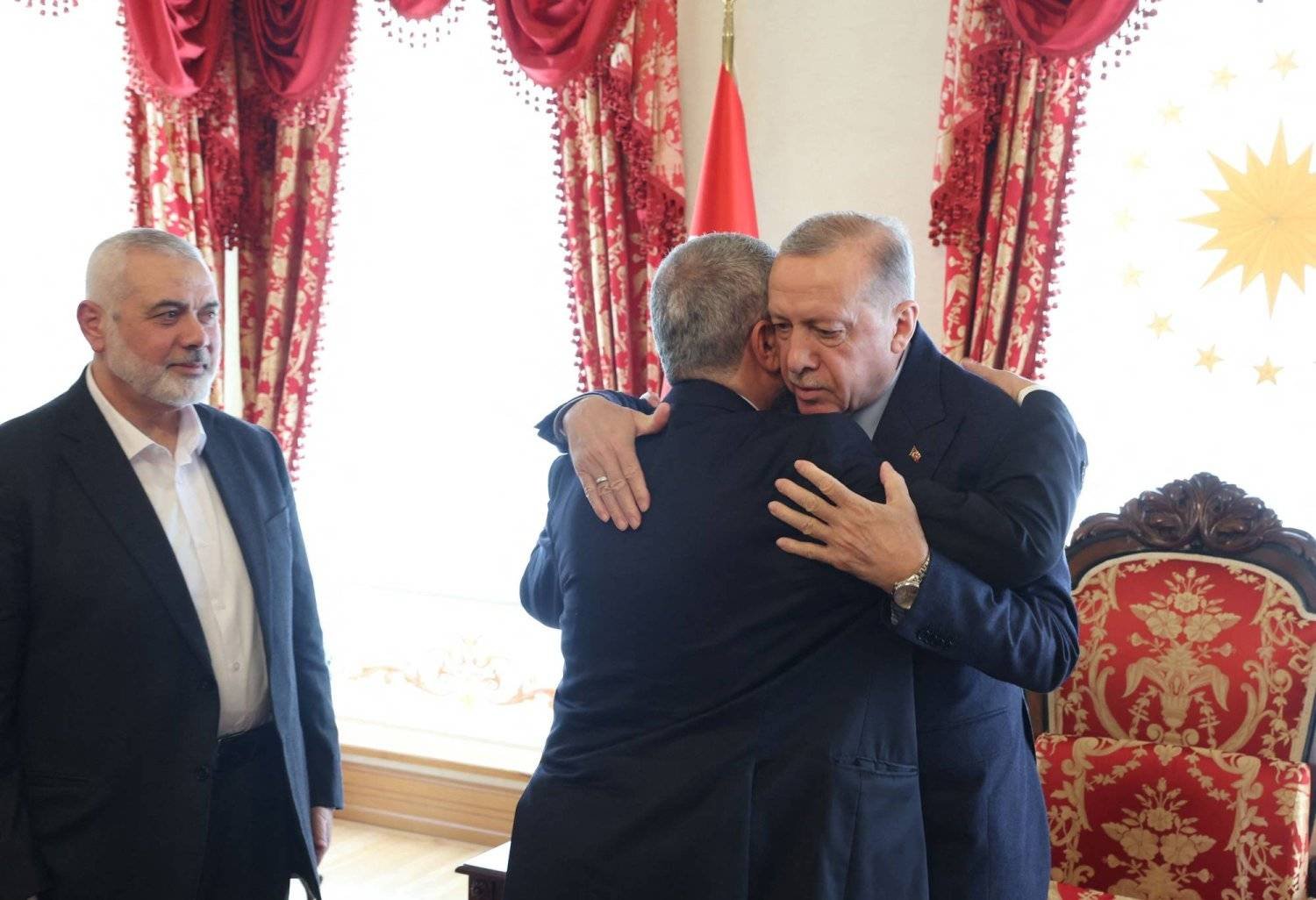 الرئيس التركي رجب طيب إردوغان يحتضن القيادي بـ«حماس» خالد مشعل وبجانبه رئيس المكتب السياسي للحركة إسماعيل هنية في إسطنبول السبت (أ.ف.ب)