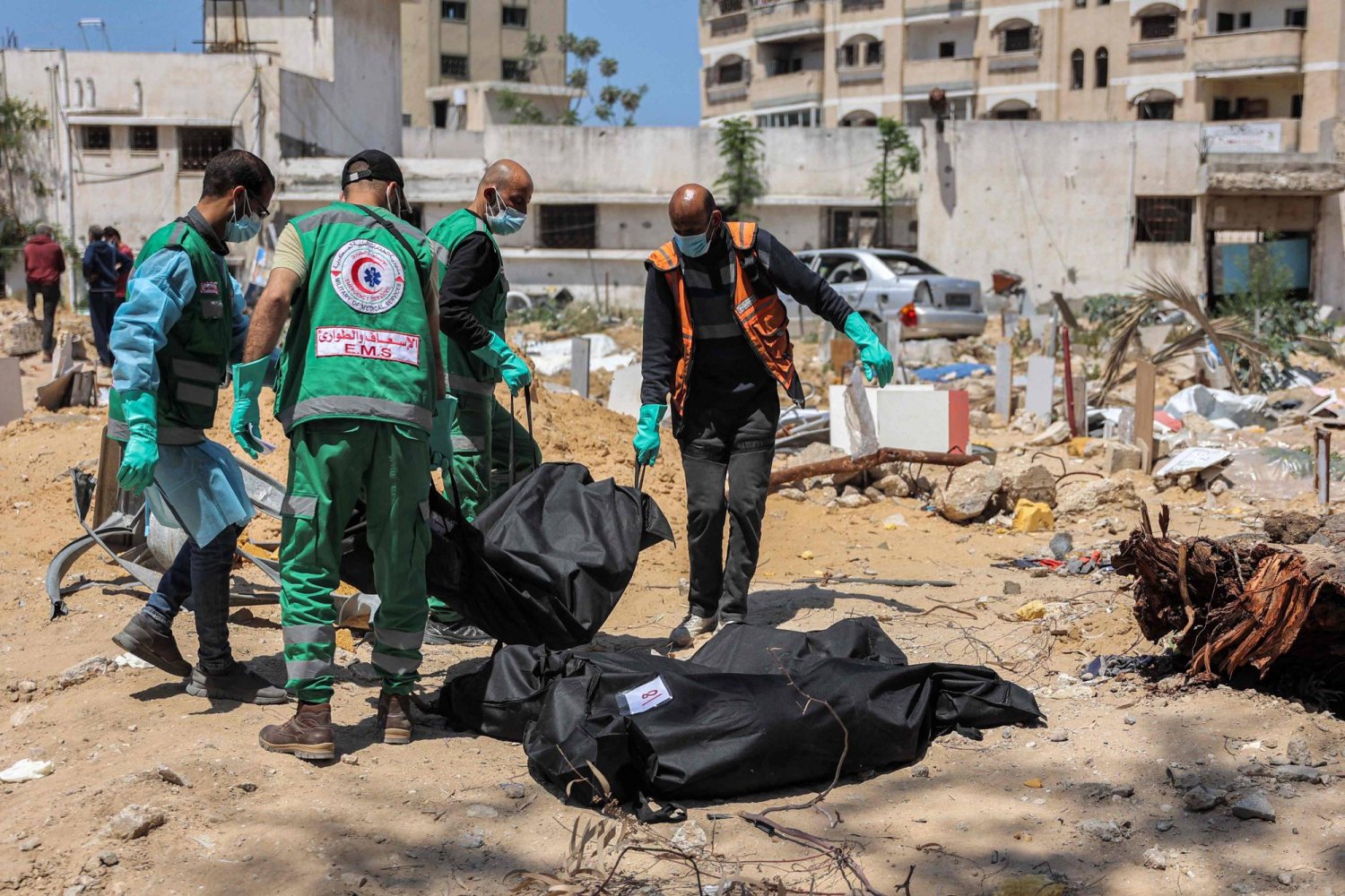 مسعفون فلسطينيون يحملون جثث القتلى التي تم اكتشافها بالقرب من مستشفى «الشفاء» في مدينة غزة في 17 أبريل 2024 بعد العملية العسكرية الإسرائيلية الأخيرة هناك (أ.ف.ب)