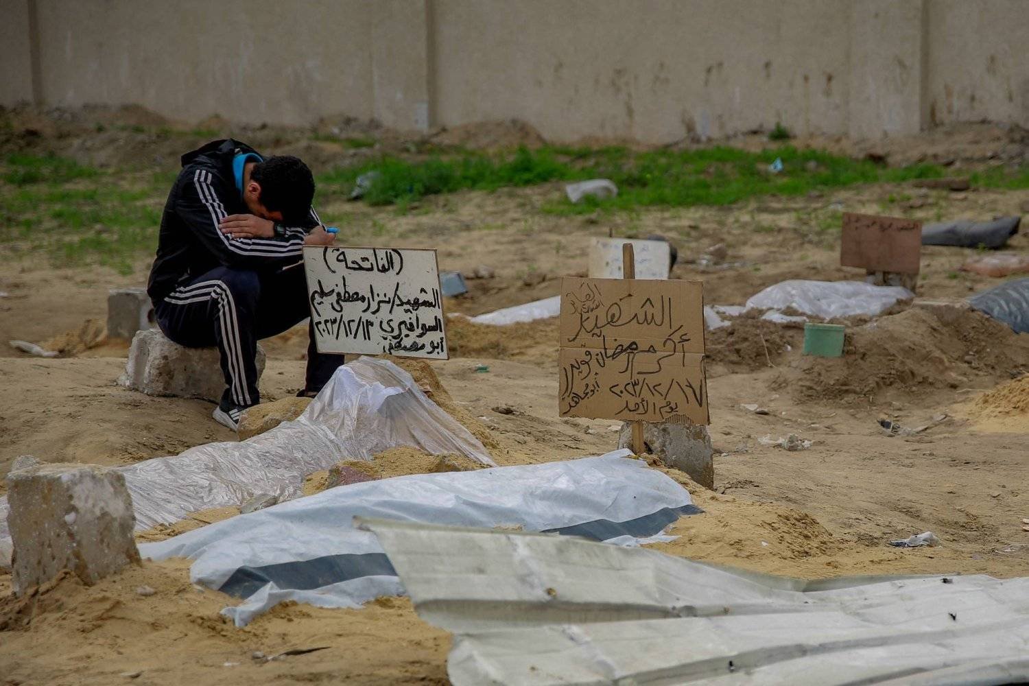 شاب فلسطيني يبكي أمام المقابر وسط الحرب الإسرائيلية على غزة (أ.ف.ب)