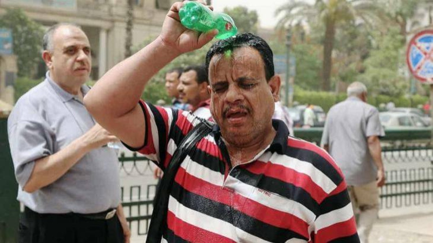 رجل يبرد نفسه من حرارة الصيف في القاهرة (أرشيفية - رويترز)