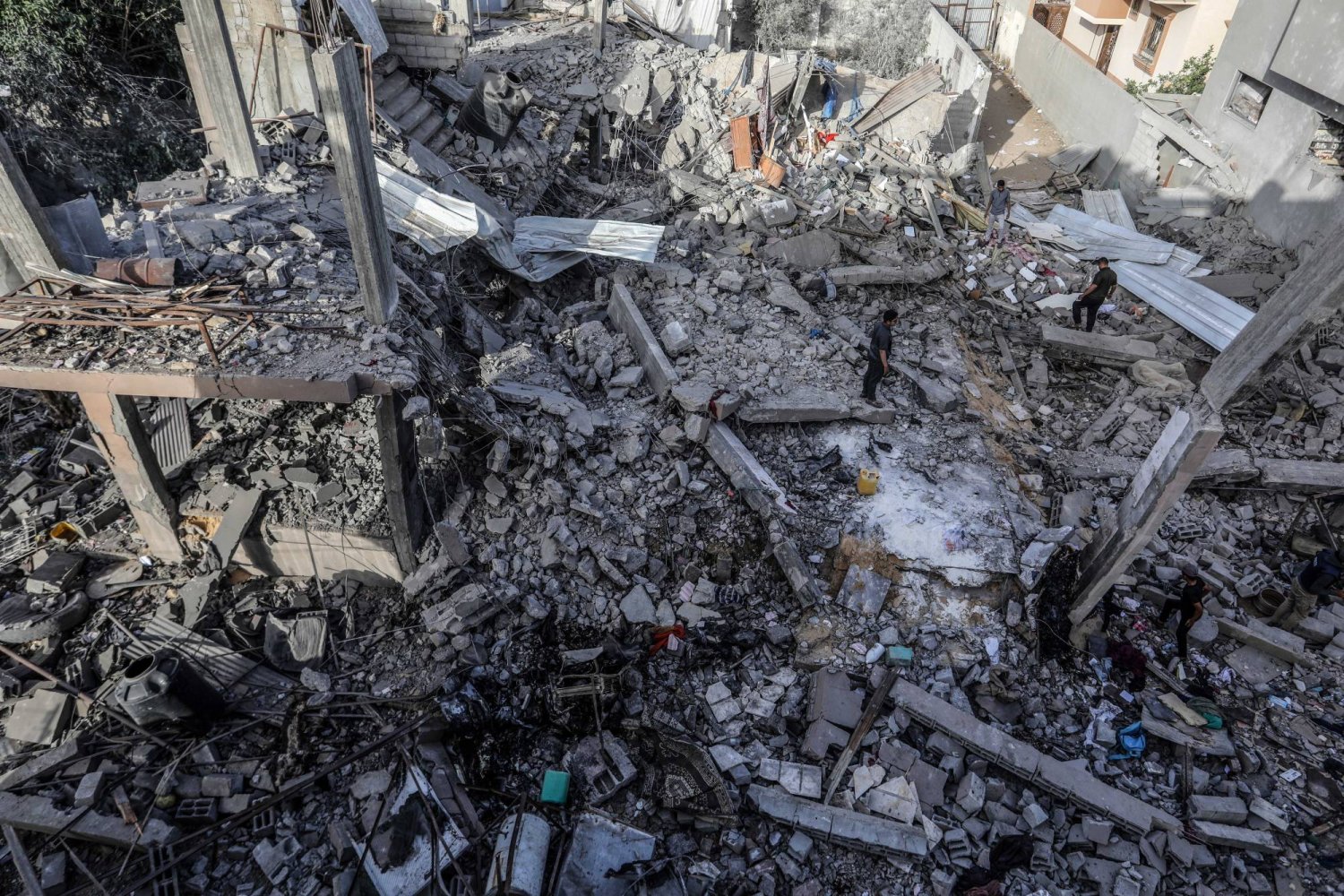 فلسطينيون يتفقدون منزلاً دُمر بعد أن قصفت طائرة إسرائيلية منزلاً ما أدى إلى استشهاد 3 أشخاص وإصابة آخرين في مدينة رفح جنوب الضفة الغربية (د.ب.أ)