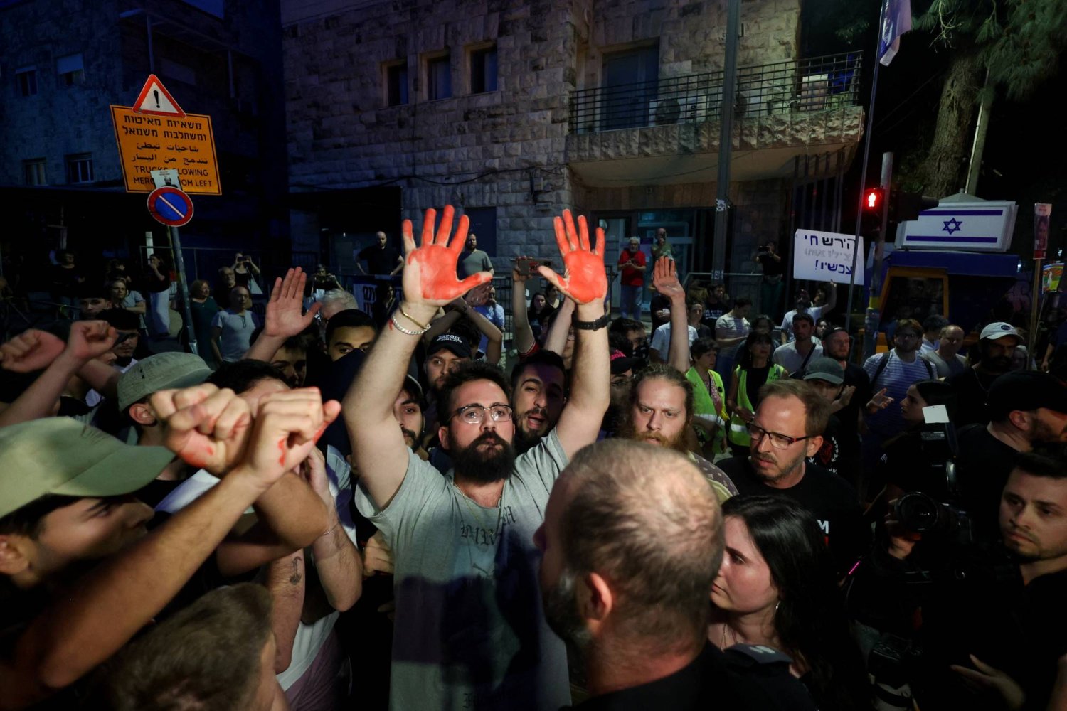 يدا متظاهر بالطلاء الأحمر أثناء مسيرة الأربعاء طالبت نتنياهو بالإفراج الفوري عن الرهائن الإسرائيليين المحتجزين في غزة (رويترز)