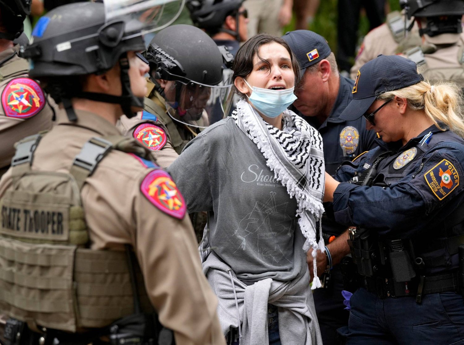 قوات الأمن تعتقل امرأة خلال احتجاجات مؤيدة للفلسطينيين في جامعة تكساس الأميركية (رويترز)