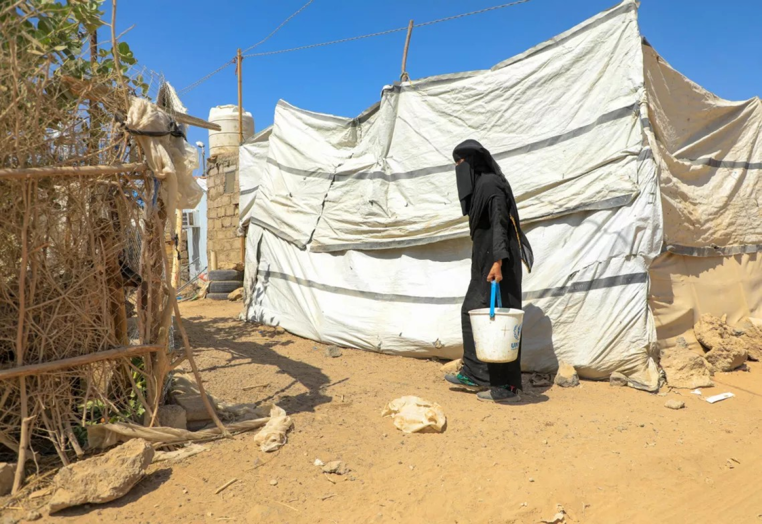 نازحة يمنية في محافظة مأرب تجلب الماء إلى خيمتها (الأمم المتحدة)