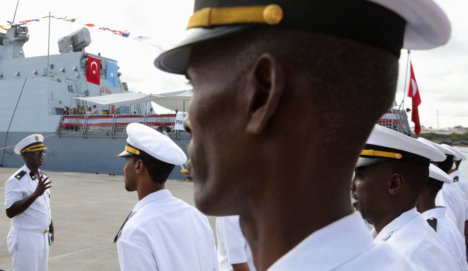 قوات عسكرية صومالية تقف بالقرب من سفينة البحرية التركية التي رست في ميناء مقديشو بعد توقيع اتفاقية دفاعية واقتصادية بين الصومال وتركيا في مقديشو الثلاثاء (رويترز)