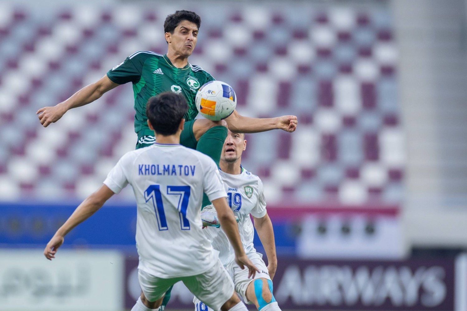فيصل الغامدي في كرة مشتركة مع لاعب أوزبكستان (المنتخب السعودي)
