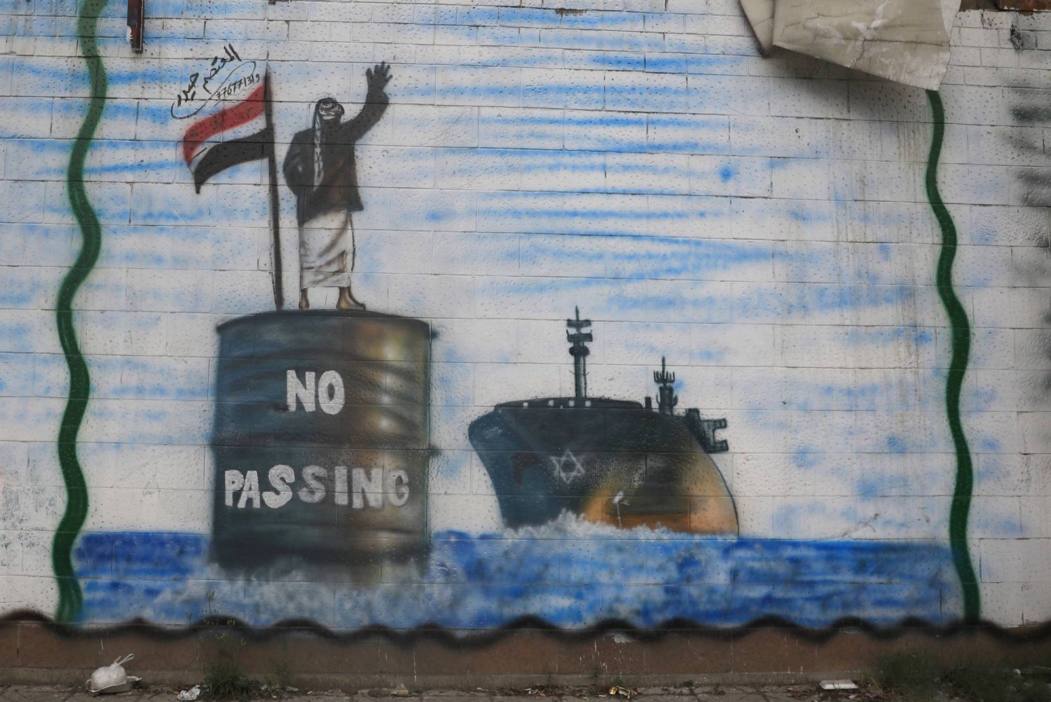 رسم على جدار في صنعاء يصور سفينة في البحر الأحمر ومقاتلاً حوثياً (إ.ب.أ)