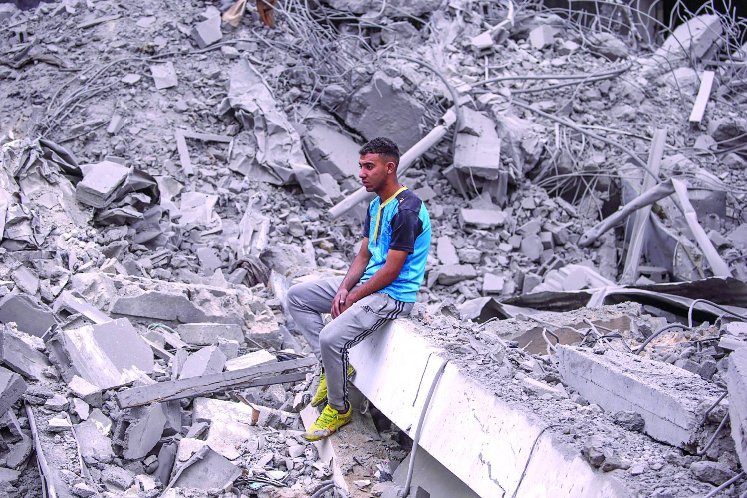 
فلسطيني وسط أنقاض أبنية دمرتها غارة إسرائيلية على النصيرات بوسط قطاع غزة أمس السبت (إ.ب.أ)