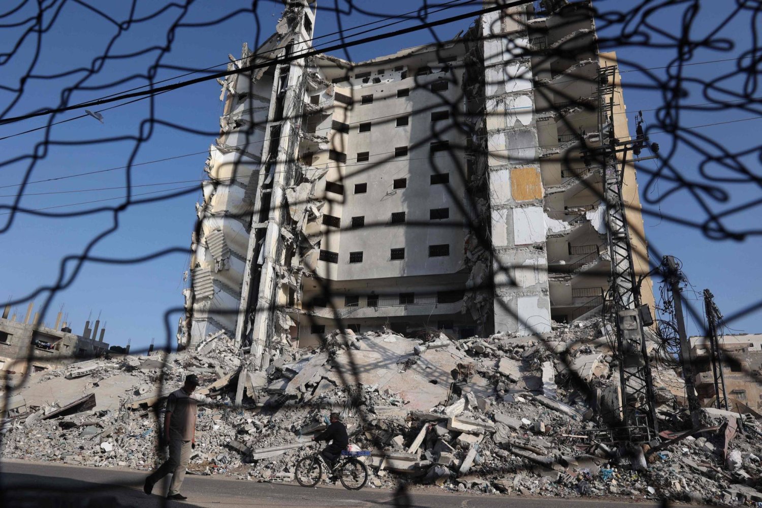 فلسطيني يمر بجانب مبنى مدمر في رفح (أ.ف.ب)