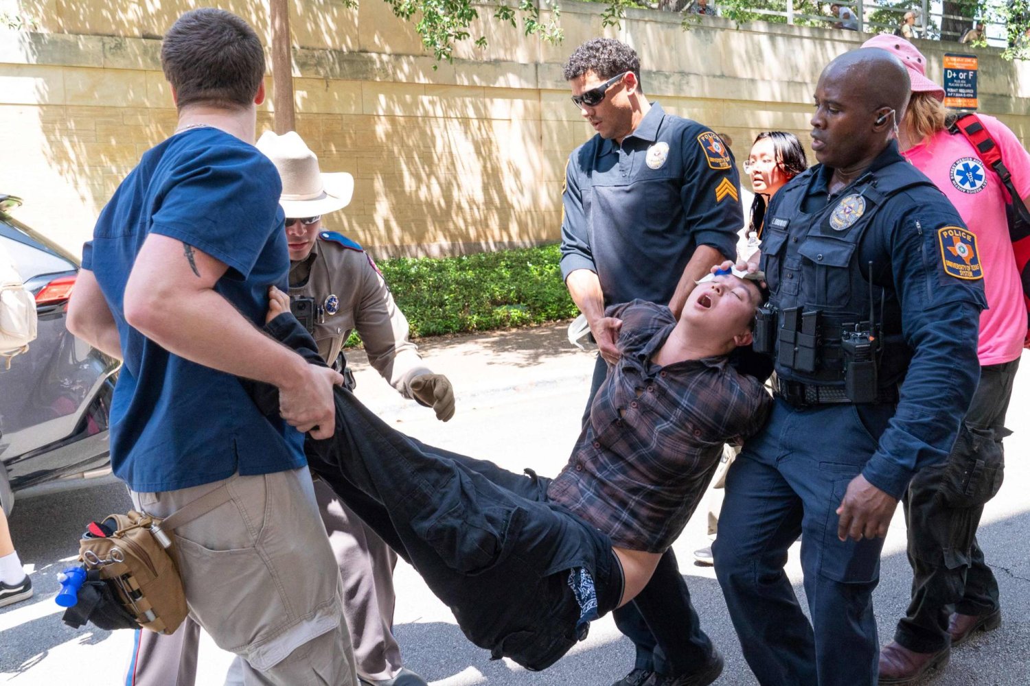 عناصر من الشرطة تحمل متظاهراً داخل جامعة تكساس (أ.ف.ب)