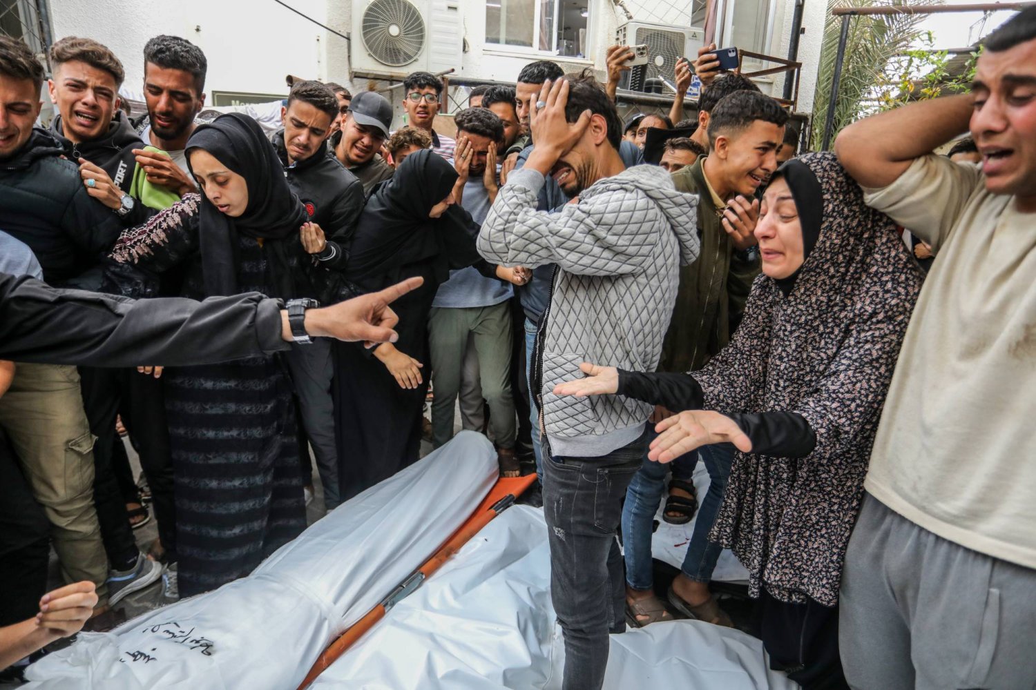 فلسطينيون يبكون أقاربهم بعد أن قُتلوا في غارة إسرائيلية على رفح (د.ب.أ)