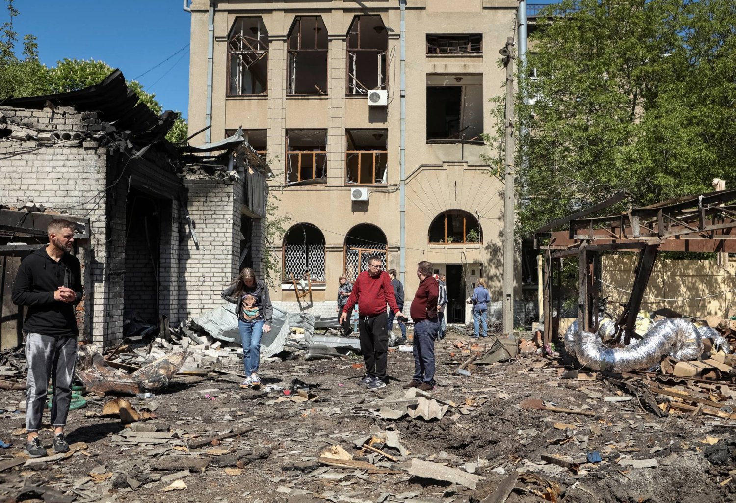 سكان محليون يتفقدون الأضرار في موقع تعرّض لضربة صاروخية روسية في خاركيف بأوكرانيا في 30 أبريل 2024 (رويترز)