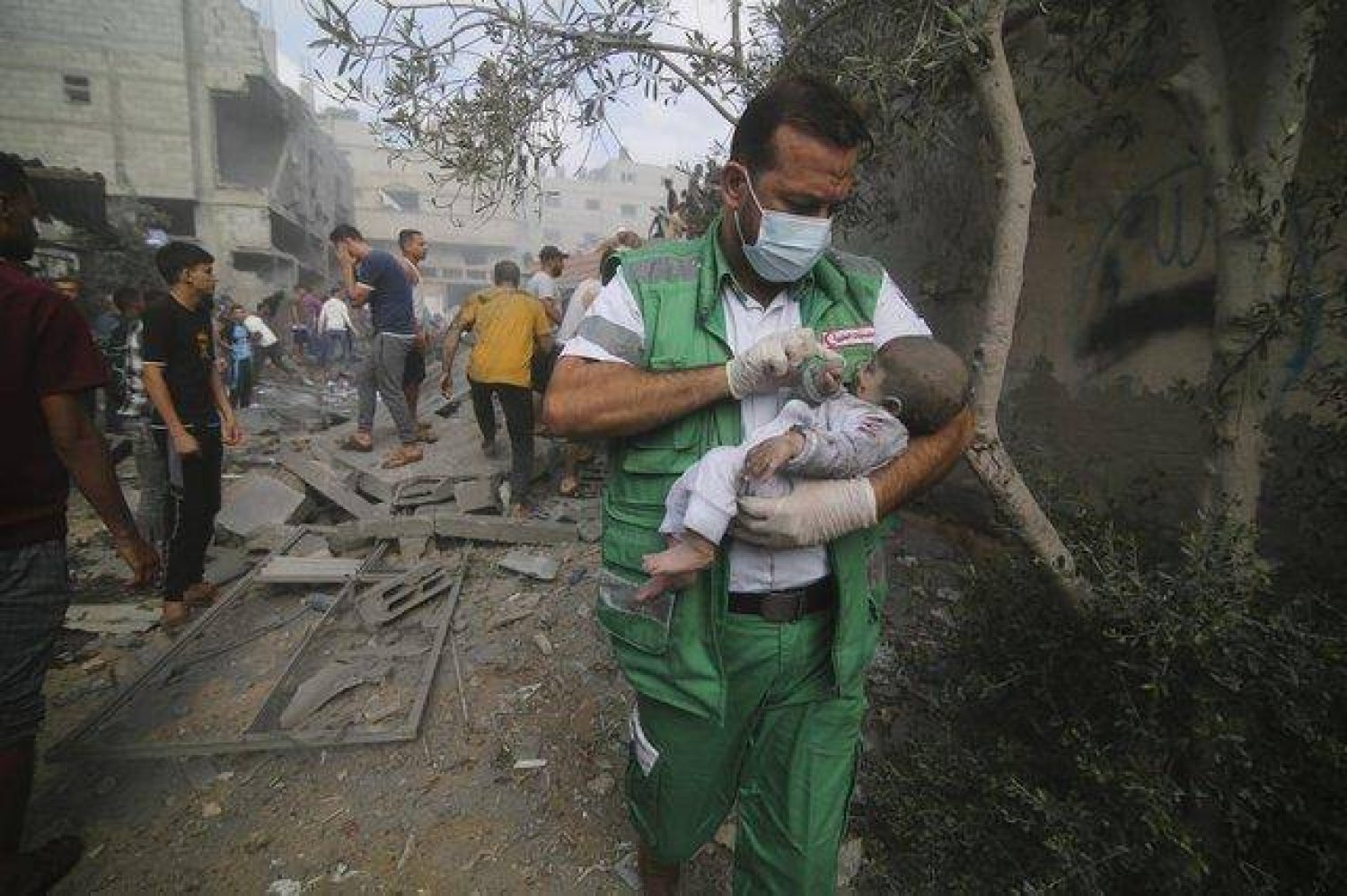 مسعف فلسطيني يحمل طفلاً جرى انتشاله من المباني المدمرة في القصف الإسرائيلي على قطاع غزة في رفح (أرشيفية - أ.ب)