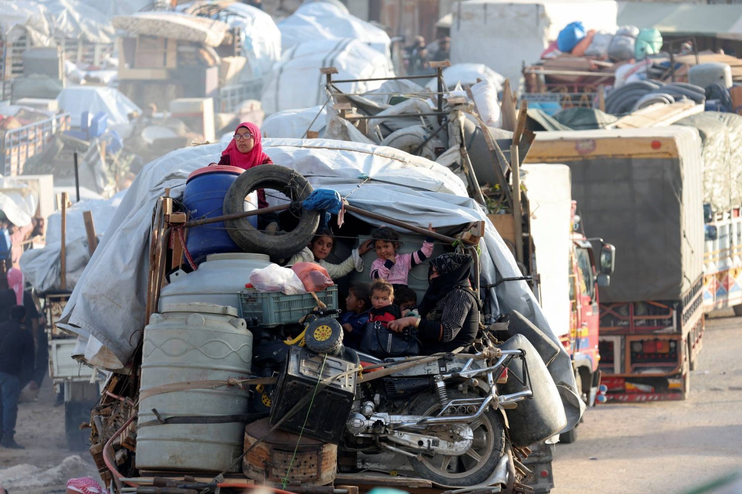 لاجئون سوريون يجلسون مع أمتعتهم على شاحنة صغيرة على مشارف بلدة عرسال الحدودية اللبنانية مع سوريا 26 أكتوبر 2022 (رويترز)