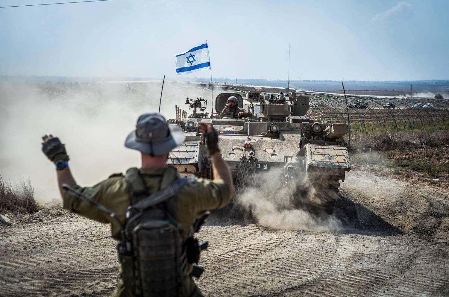 جندي إسرائيلي يوجِّه دبابة قرب حدود غزة (د.ب.أ)