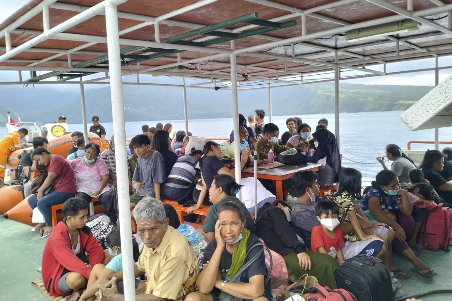 سكان جزيرة تغجولاندانغ على متن سفينة تابعة للوكالة الوطنية للبحث والإنقاذ للإخلاء بعد ثوران جبل روانغ في جزيرة سولاويزي (أ.ب)
